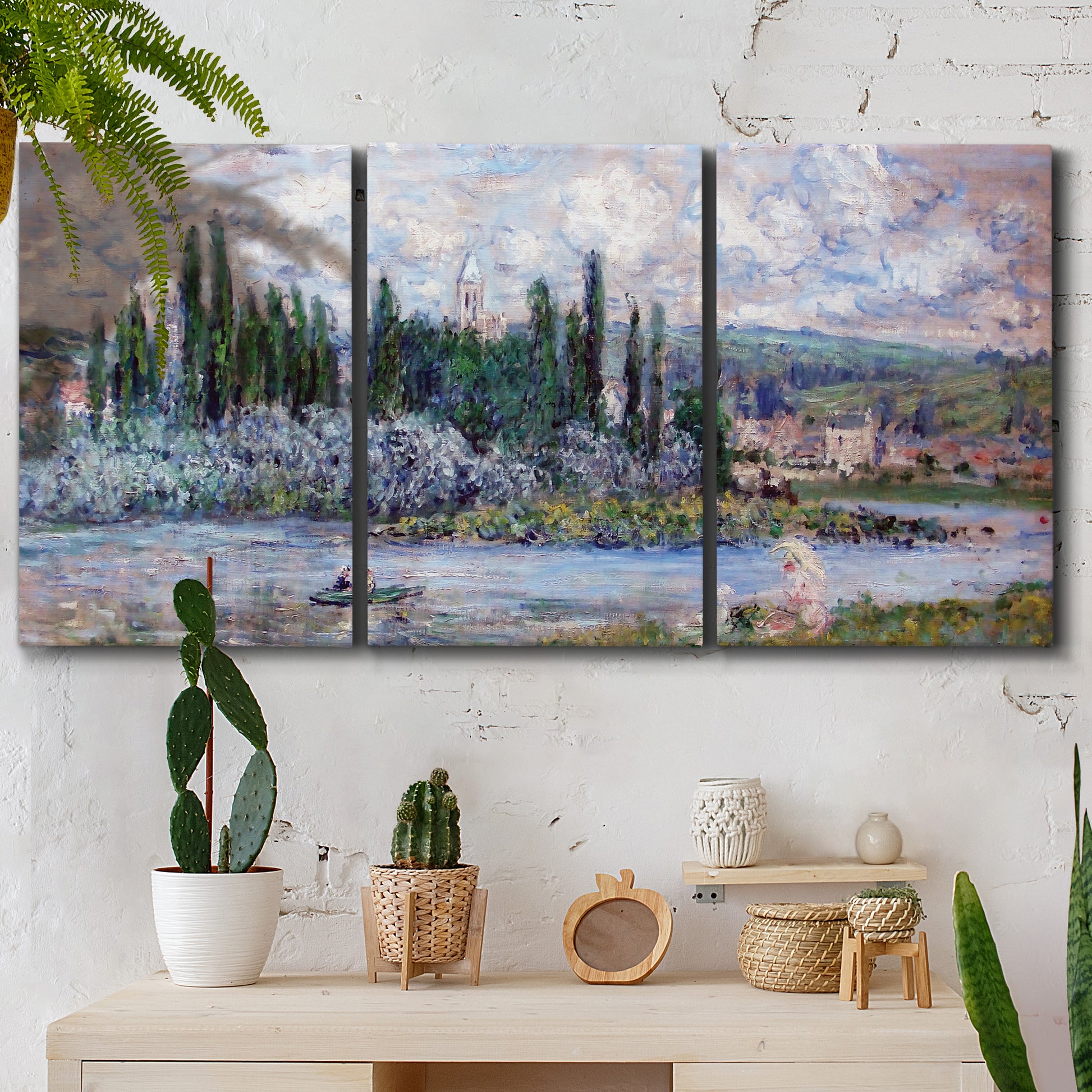Three-panel canvas wall art featuring summer village view along river, displayed in a boho-chic entryway above a console table.