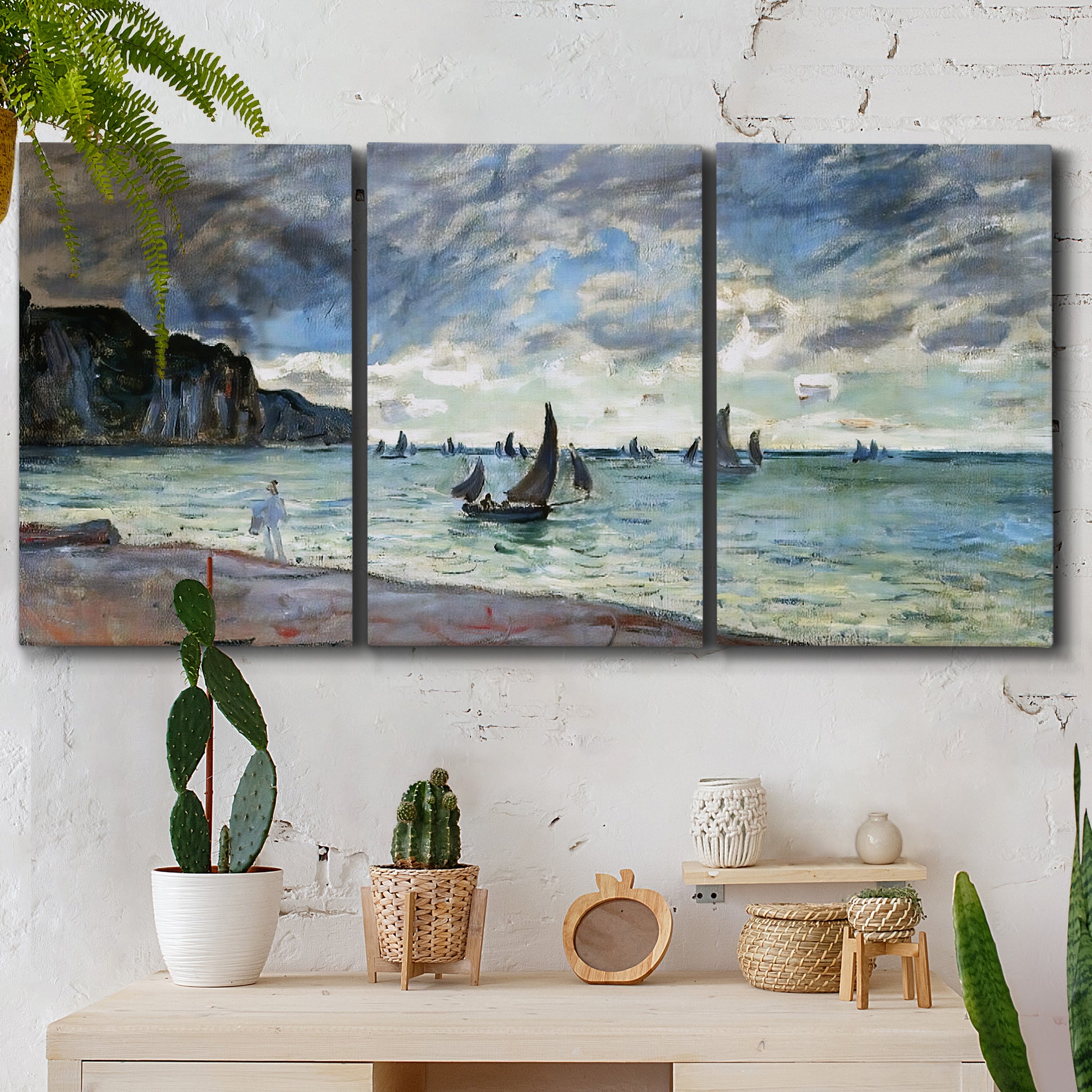 Three-panel canvas wall art featuring figures walking along sandy shoreline, displayed in a boho-chic entryway above a console table.