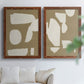 Set of two maple barnwood framed canvas prints depicting flat blocky forms, rough painted edges, and strong negative space arranged across two complementary compositions above a sofa in a bright living space.