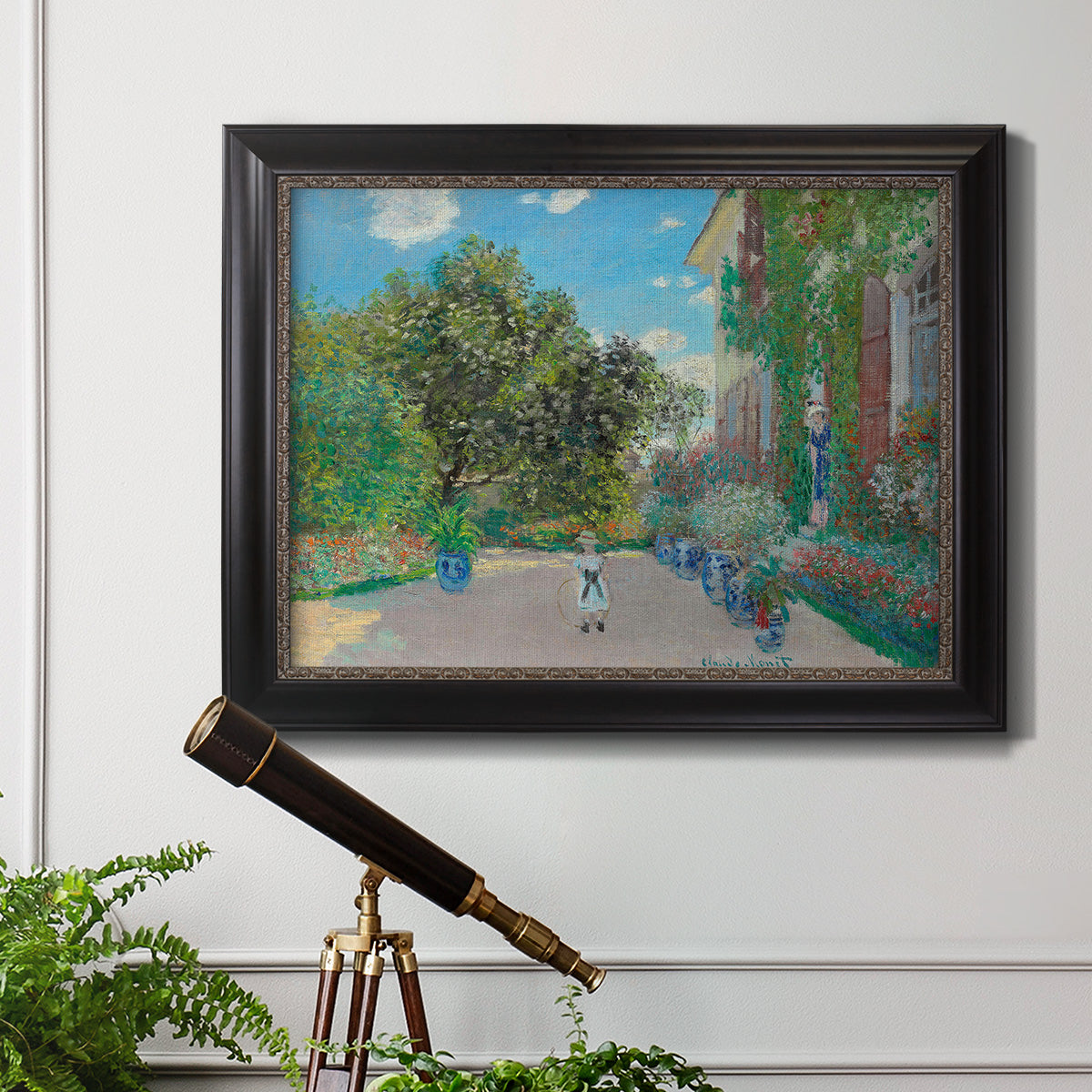 Impressionist residential landscape at Argenteuil by Claude Monet in an ornate black frame with gilded inner detail displayed in a light-toned interior setting.