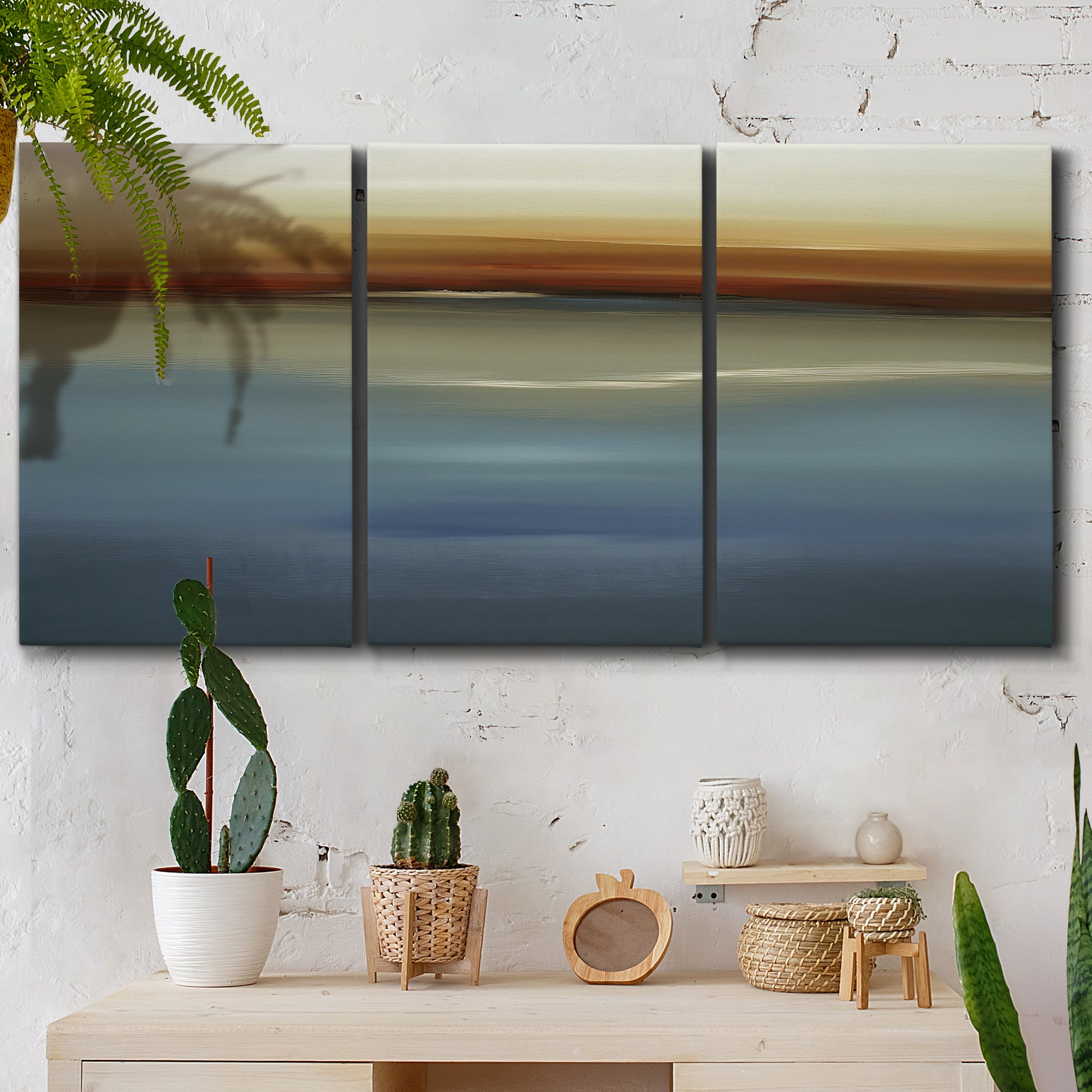 Three-panel canvas wall art featuring horizontal abstract coastal color bands, displayed in a boho-chic entryway above a console table.