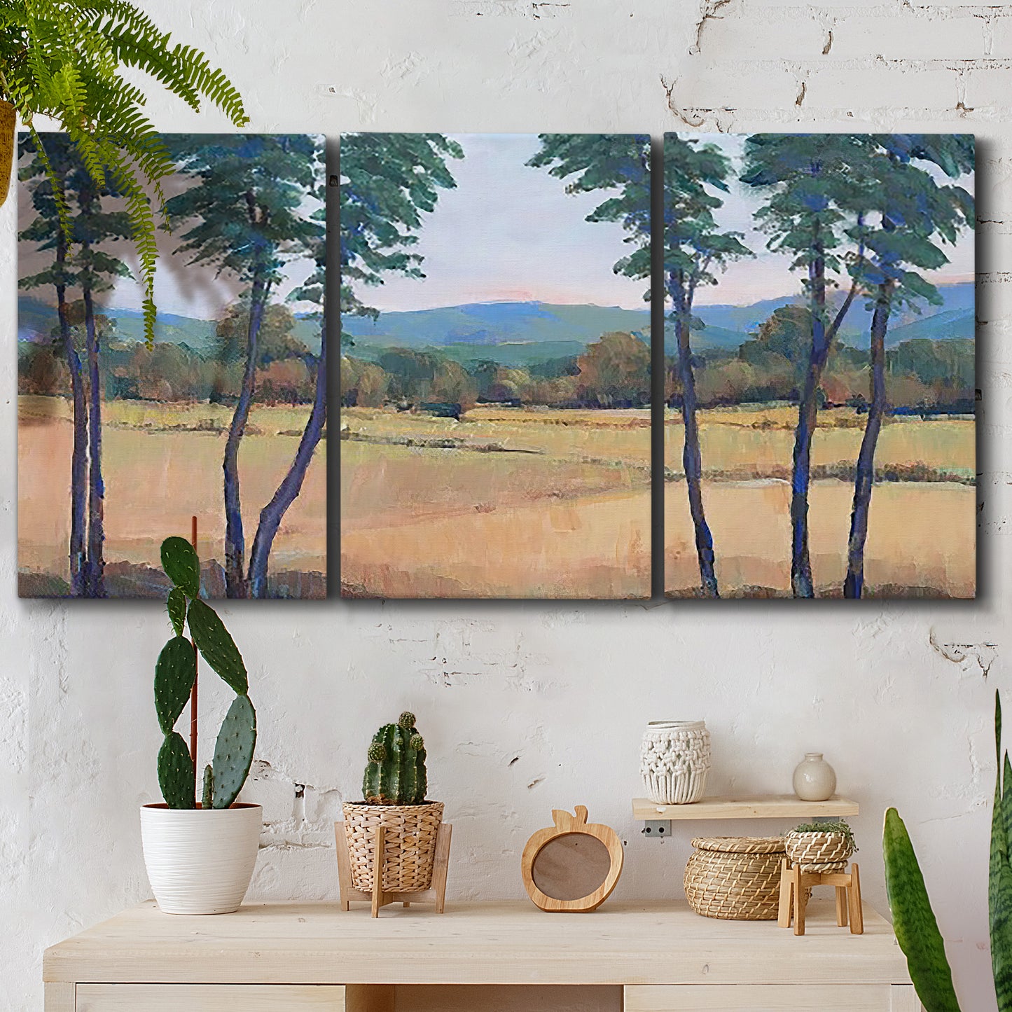 Three-panel canvas wall art featuring quiet morning landscape with trees, displayed in a boho-chic entryway above a console table.
