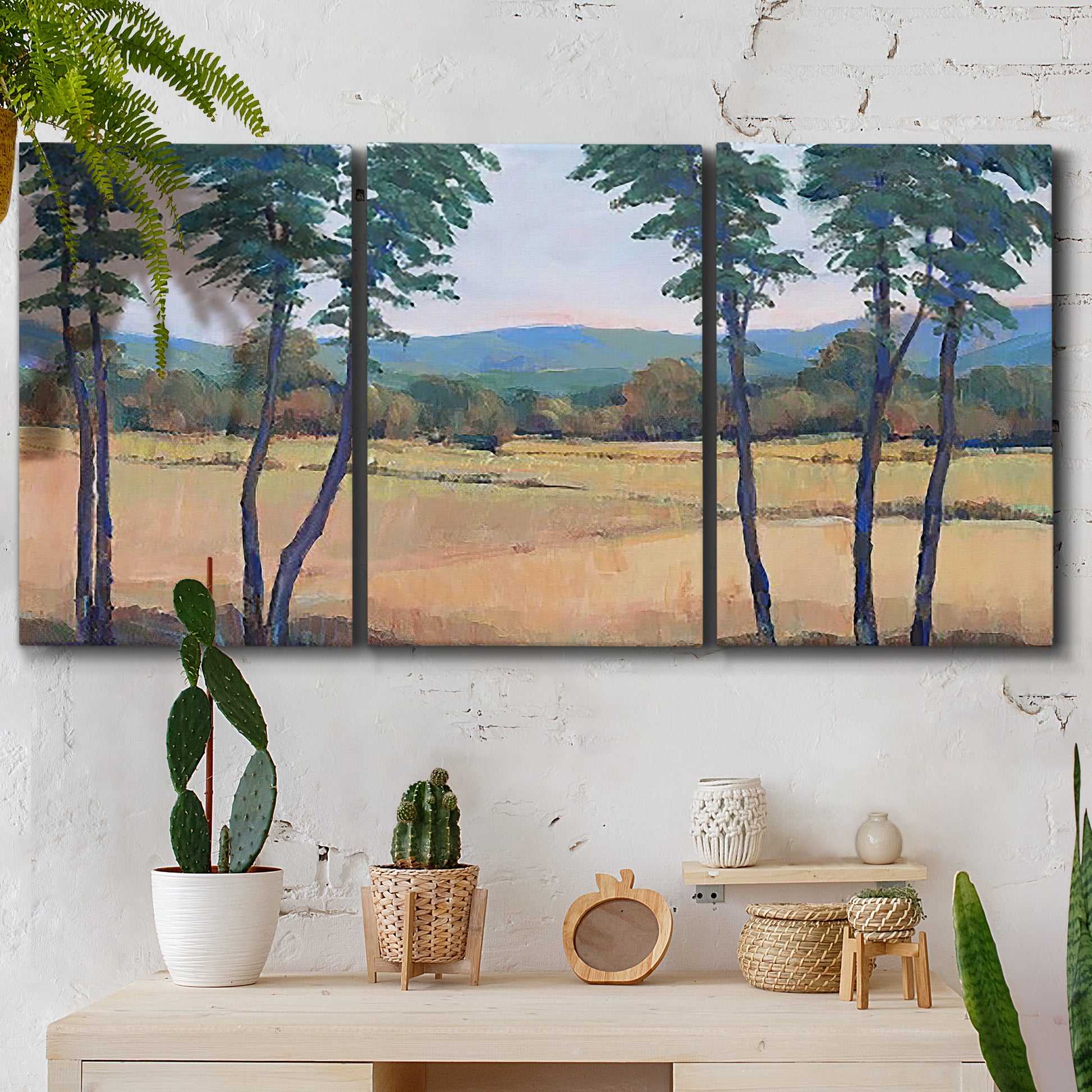 Three-panel canvas wall art featuring quiet morning landscape with trees, displayed in a boho-chic entryway above a console table.