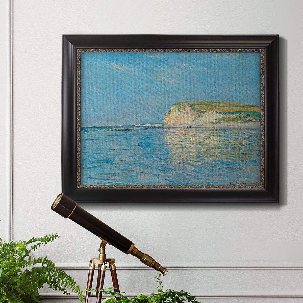 Impressionist coastal low-tide seascape at Pourville by Claude Monet in an ornate black frame with gilded inner detail displayed in a light-toned interior setting.