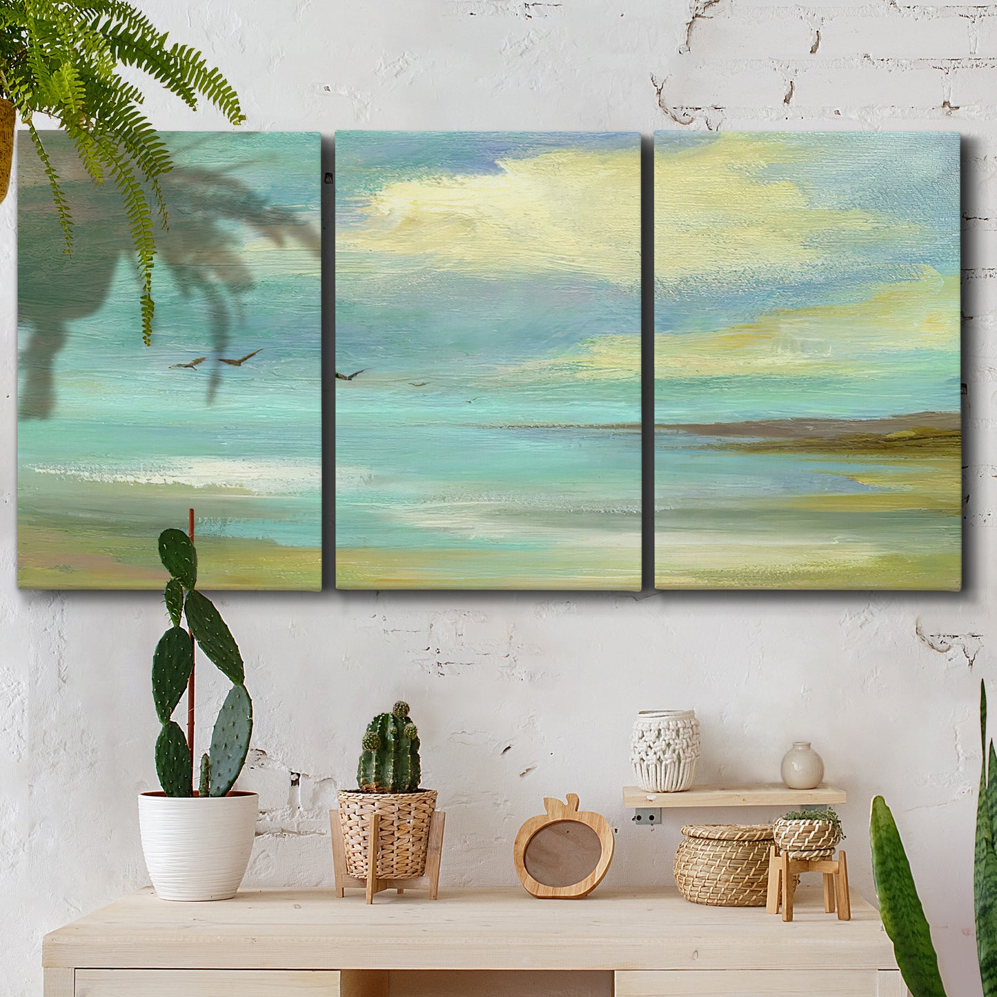 Three-panel canvas wall art featuring calm coastal drift patterns, displayed in a boho-chic entryway above a console table.