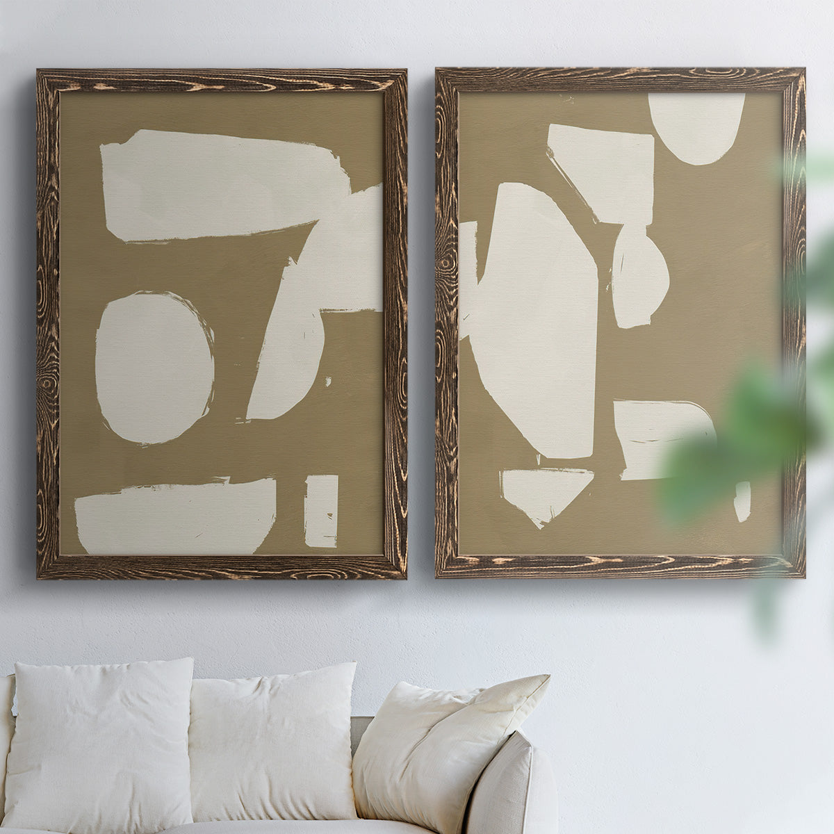 Set of two walnut barnwood framed canvas prints depicting flat blocky forms, rough painted edges, and strong negative space arranged across two complementary compositions above a sofa in a bright living space.
