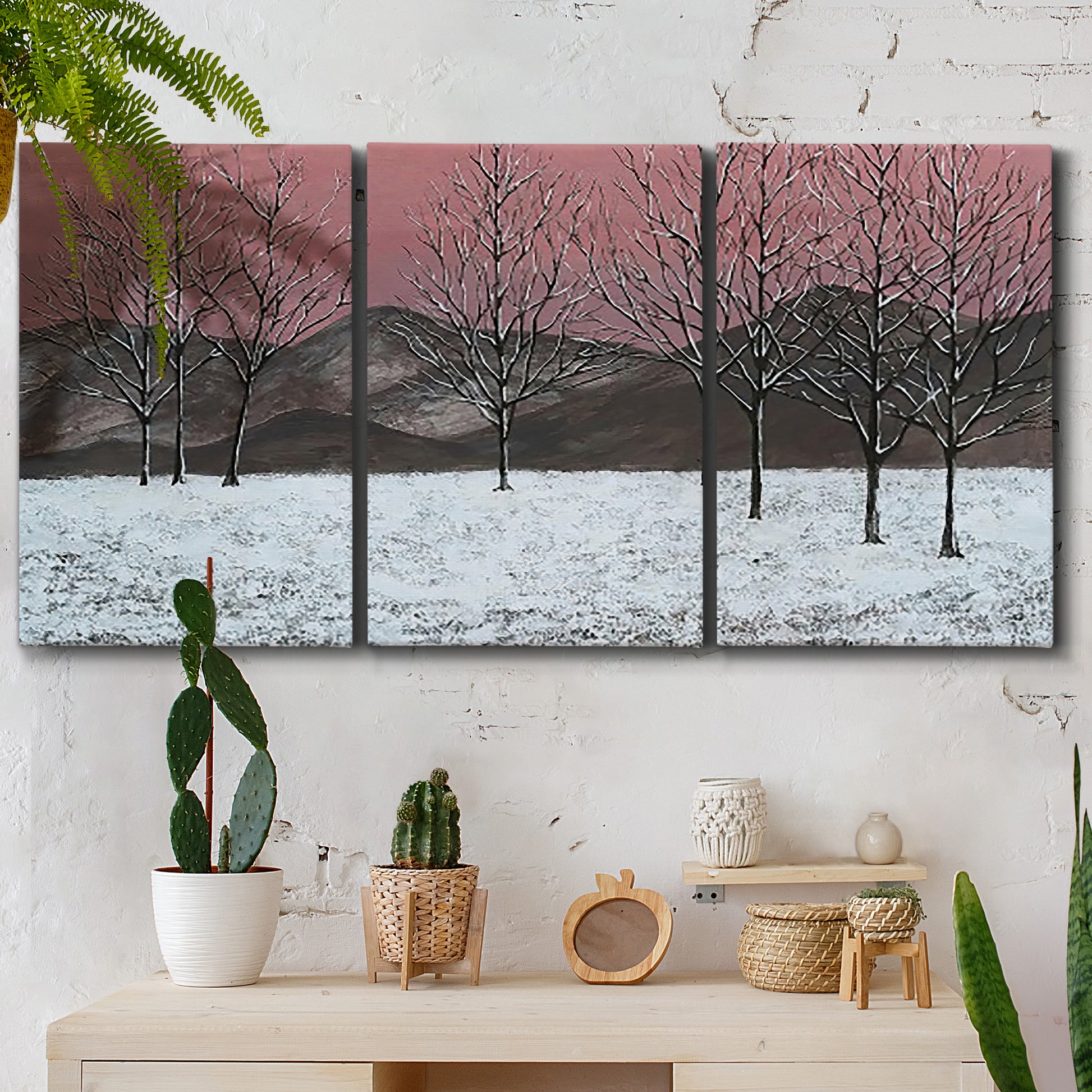 Three-panel canvas wall art featuring winter sunset snowfall landscape, displayed in a boho-chic entryway above a console table.