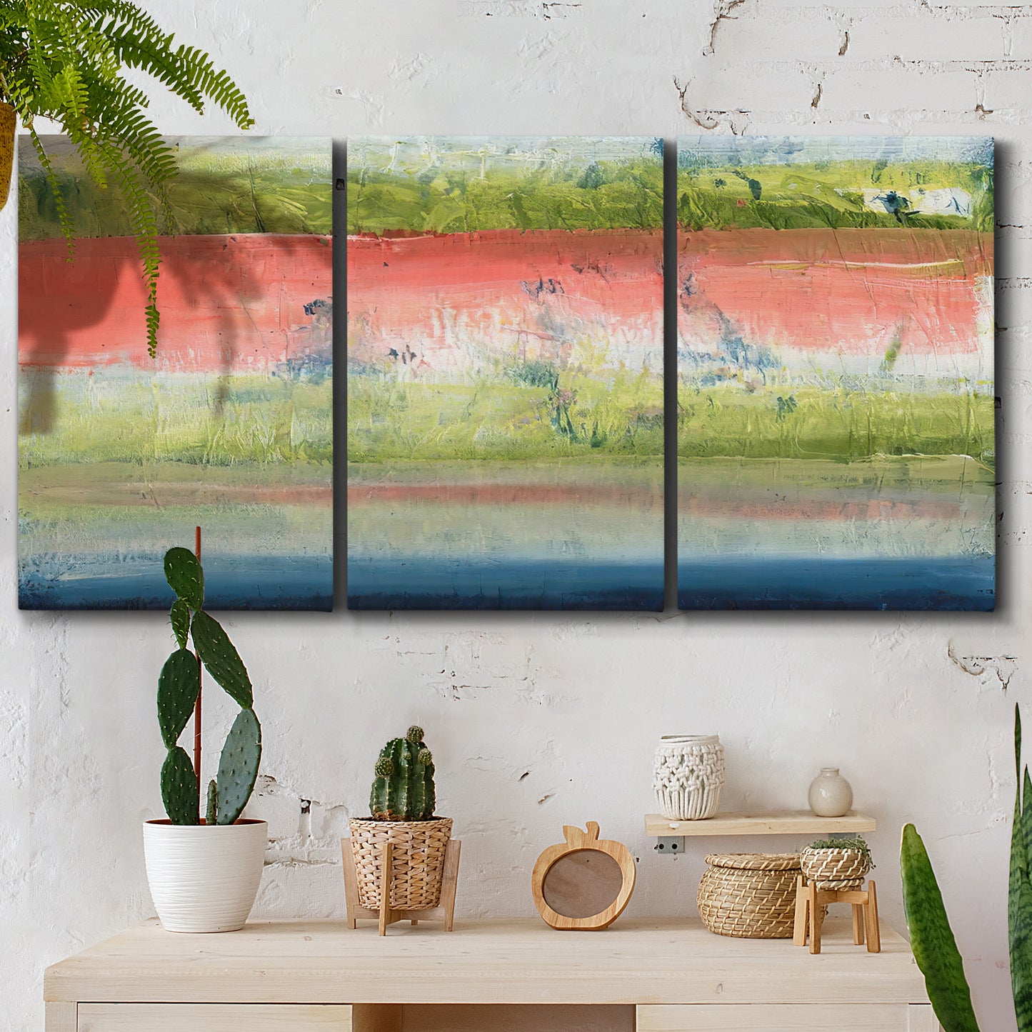 Three-panel canvas wall art featuring layered abstract color banding, displayed in a boho-chic entryway above a console table.