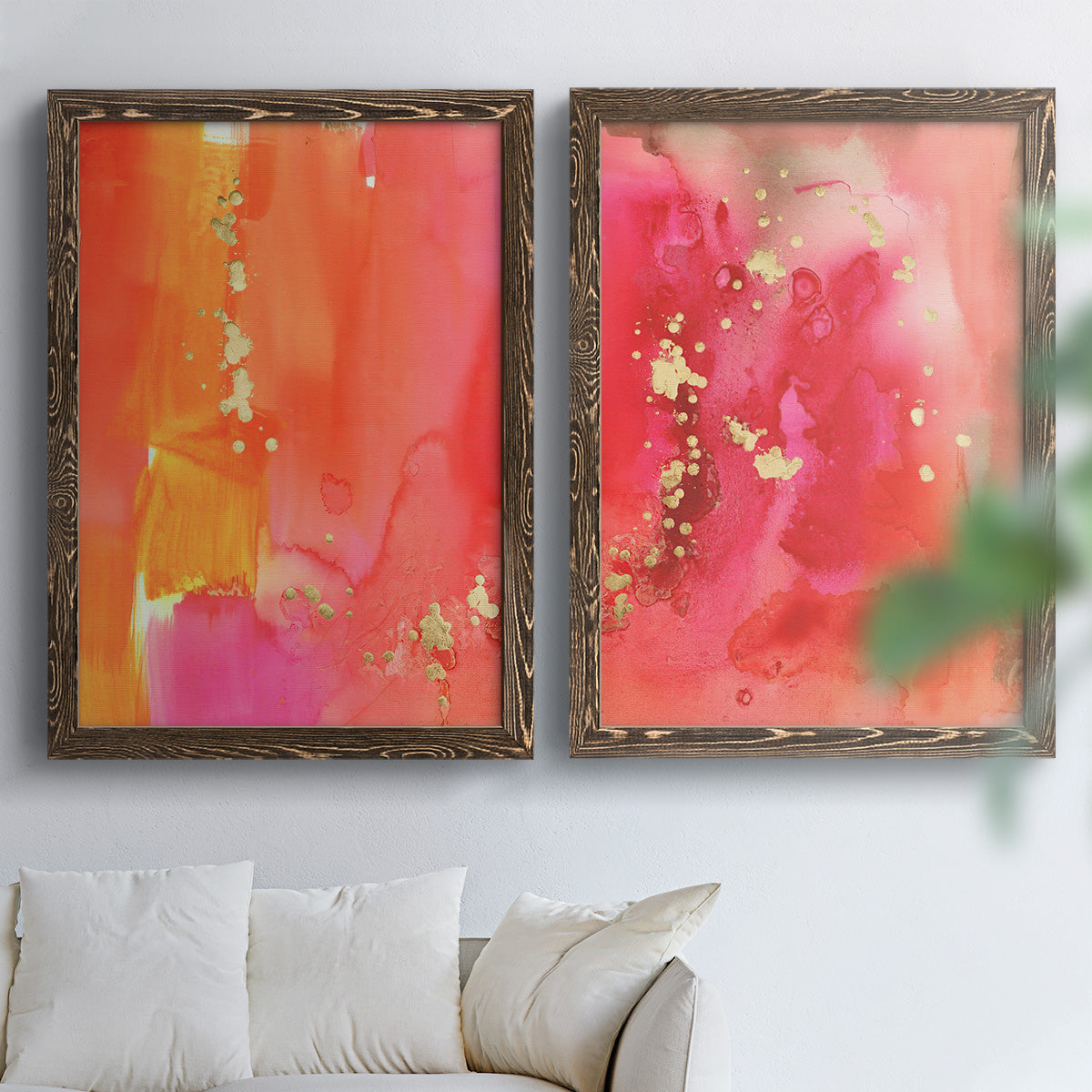 Set of two walnut barnwood framed canvas prints depicting translucent warm washes, drips, and scattered metallic accents arranged across two complementary compositions above a sofa in a bright living space.