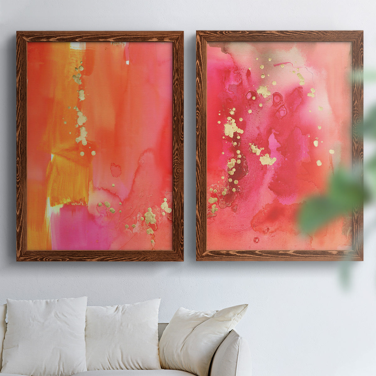 Set of two maple barnwood framed canvas prints depicting translucent warm washes, drips, and scattered metallic accents arranged across two complementary compositions above a sofa in a bright living space.