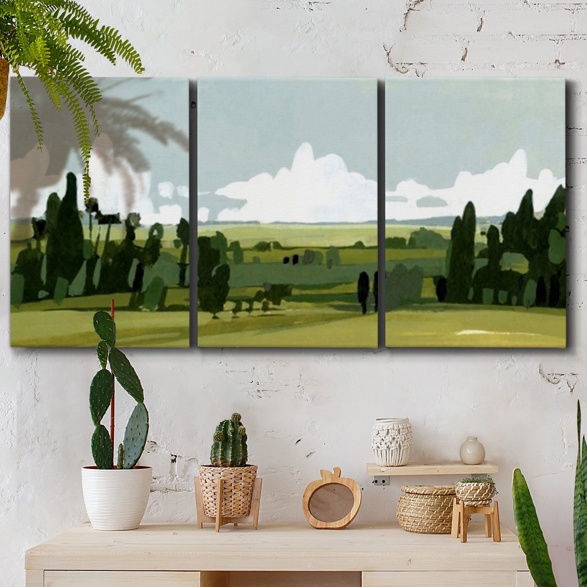 Three-panel canvas wall art featuring lush green summer countryside, displayed in a boho-chic entryway above a console table.