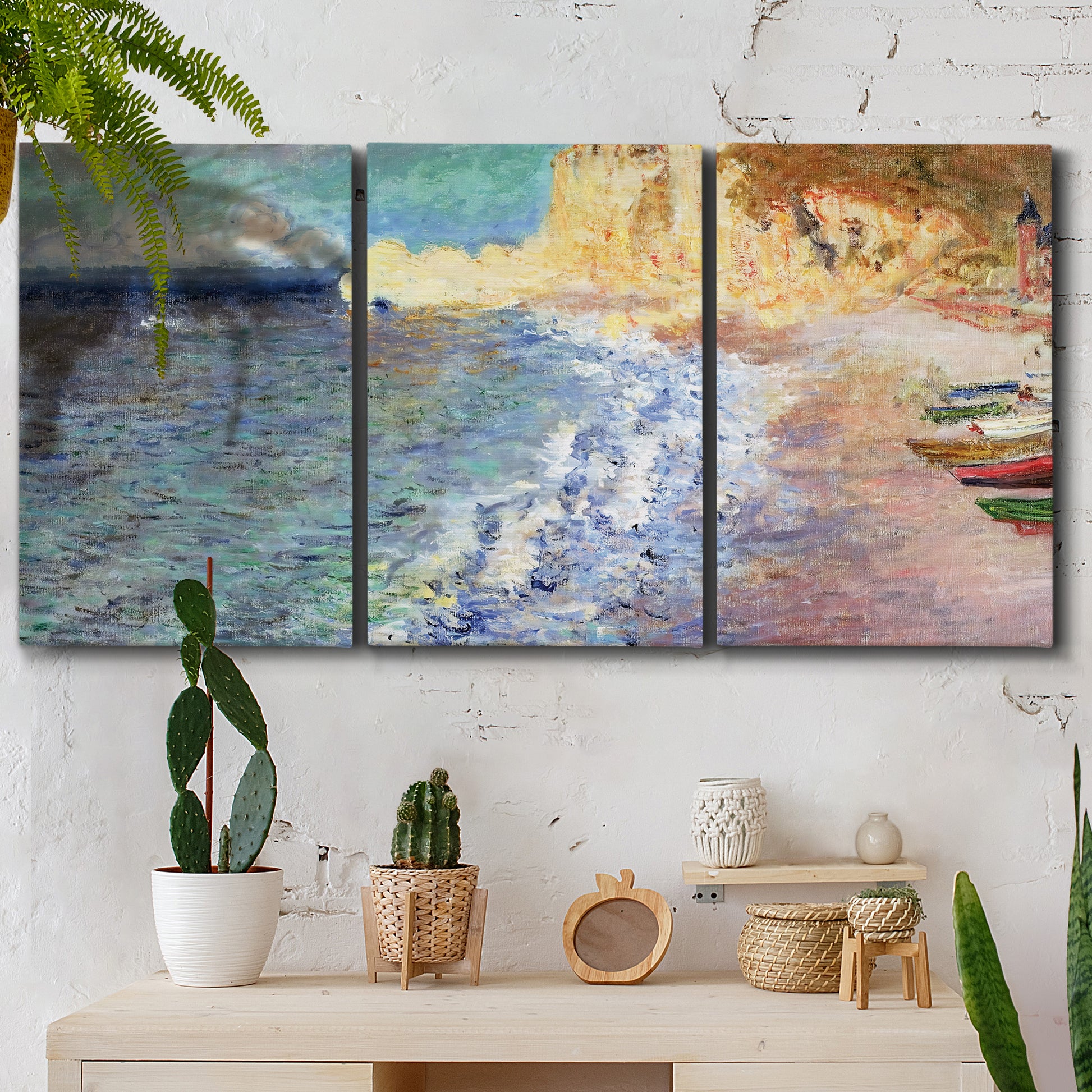 Three-panel canvas wall art featuring figures along rocky beach, displayed in a boho-chic entryway above a console table.