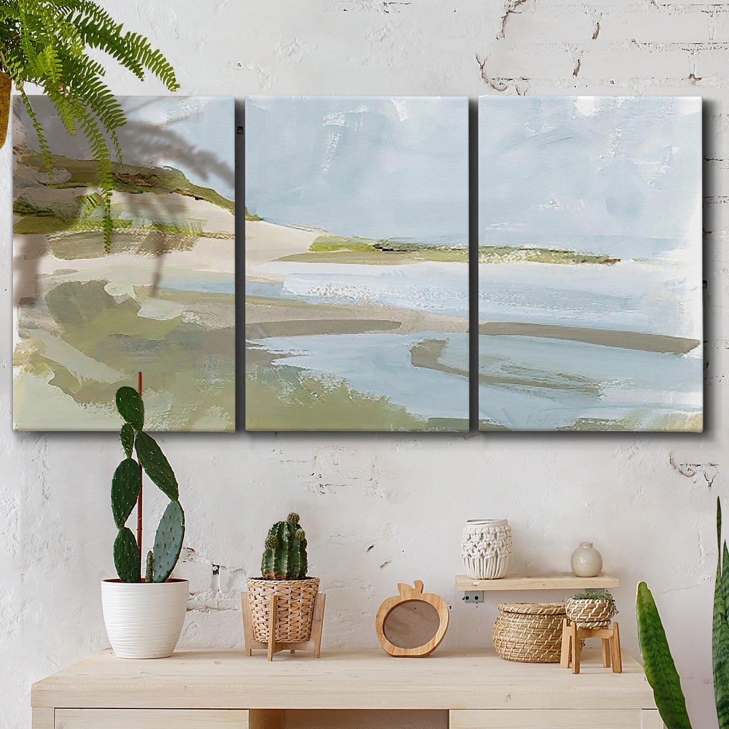 Three-panel canvas wall art featuring coastal cove with calm water, displayed in a boho-chic entryway above a console table.
