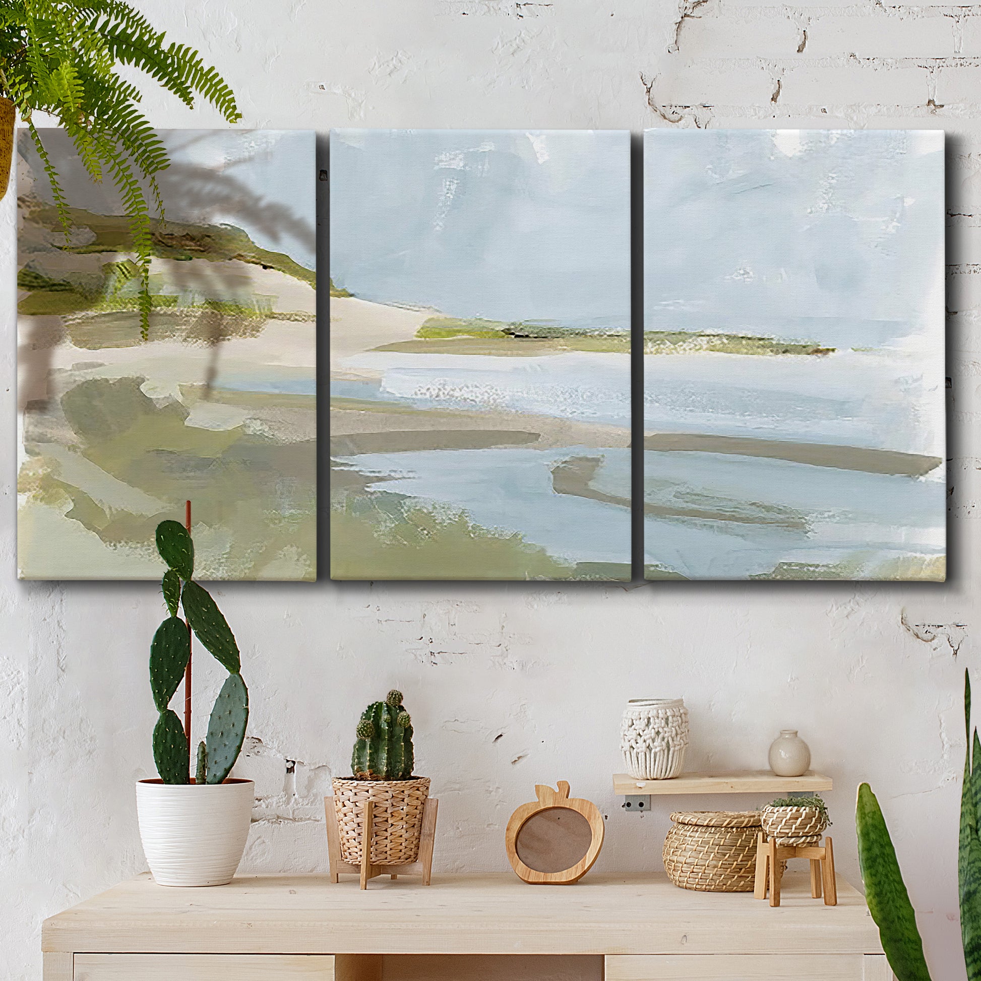 Three-panel canvas wall art featuring coastal cove with calm water, displayed in a boho-chic entryway above a console table.