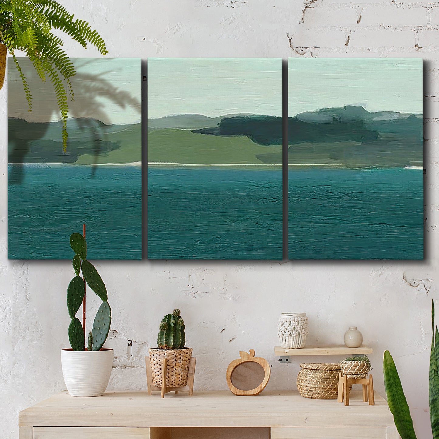 Three-panel canvas wall art featuring calm lake water under open sky, displayed in a boho-chic entryway above a console table.