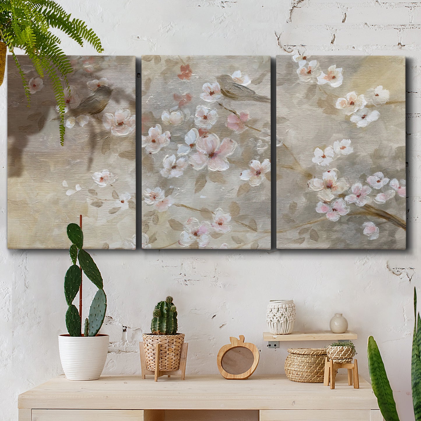 Three-panel canvas wall art featuring early spring blossoms in soft tones, displayed in a boho-chic entryway above a console table.