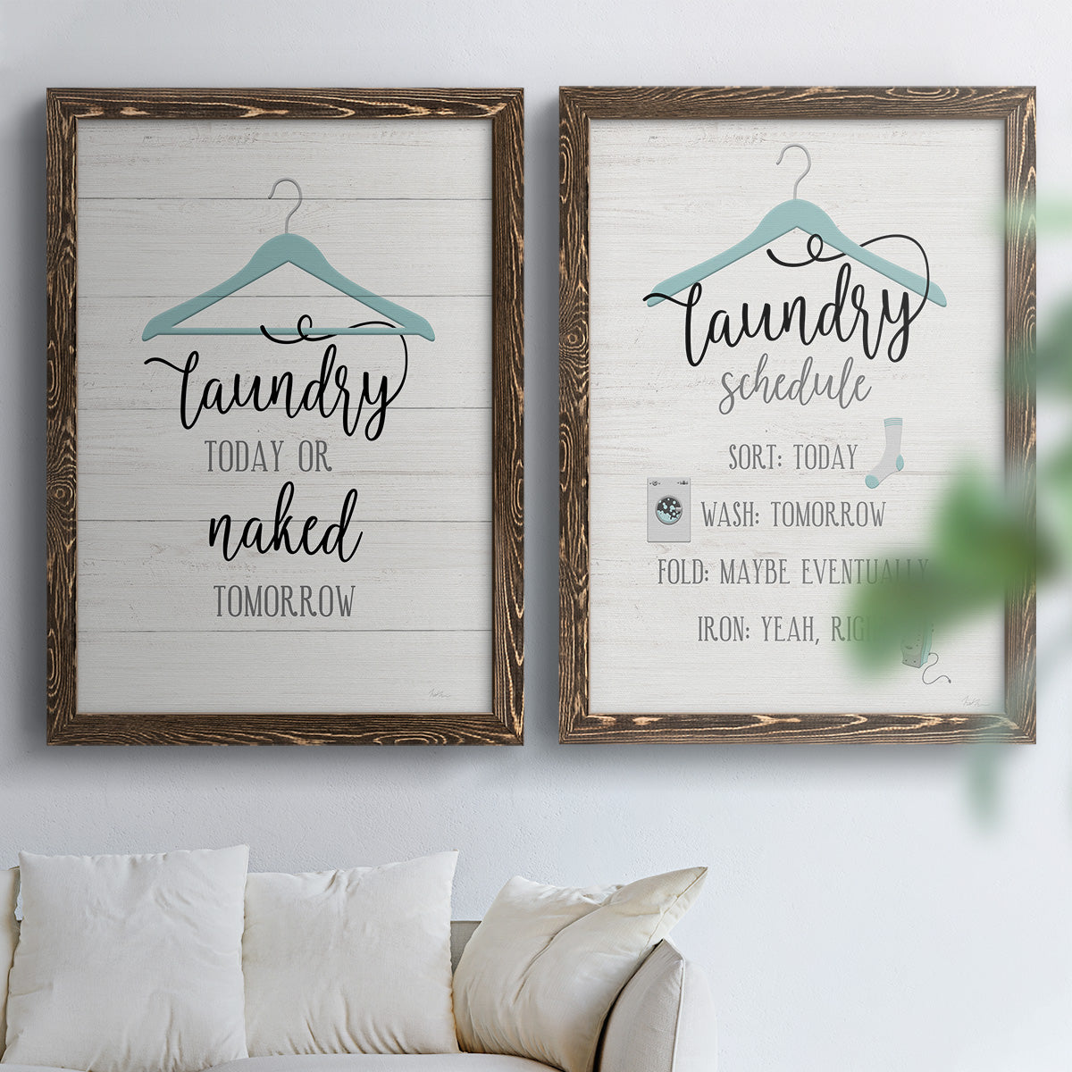 Set of two walnut barnwood framed canvas prints depicting hand-lettered phrases, socks hangers and laundry symbols on linen texture arranged across two complementary compositions above a sofa in a bright living space.