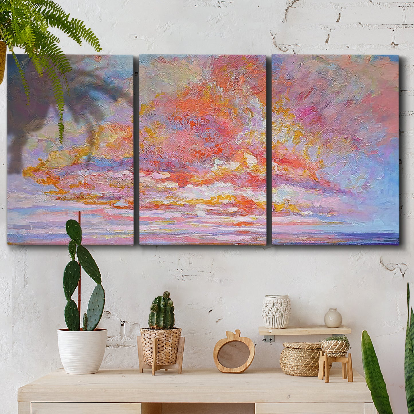 Three-panel canvas wall art featuring peaceful tropical inspired landscape, displayed in a boho-chic entryway above a console table.