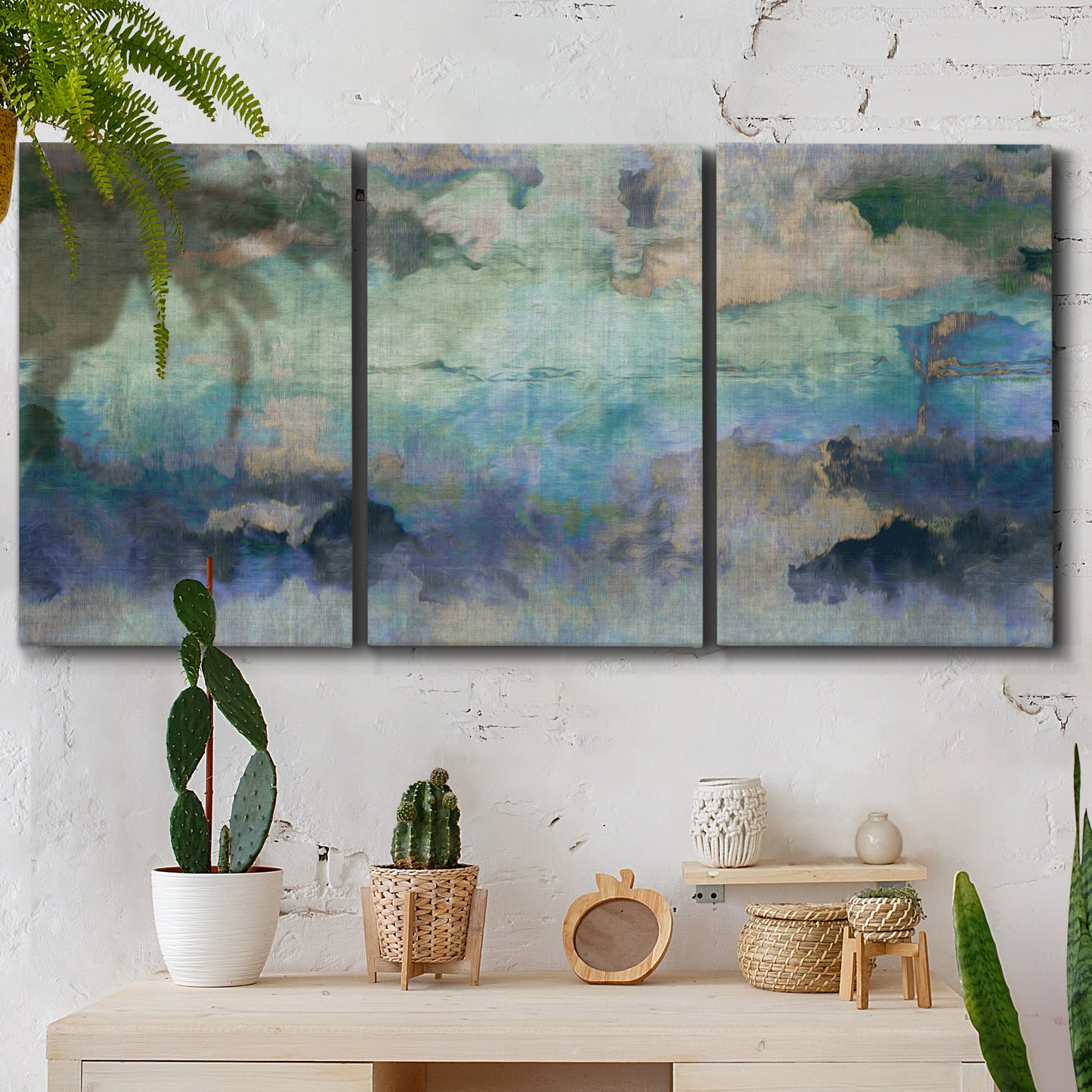 Three-panel canvas wall art featuring cool dreamy abstraction, displayed in a boho-chic entryway above a console table.