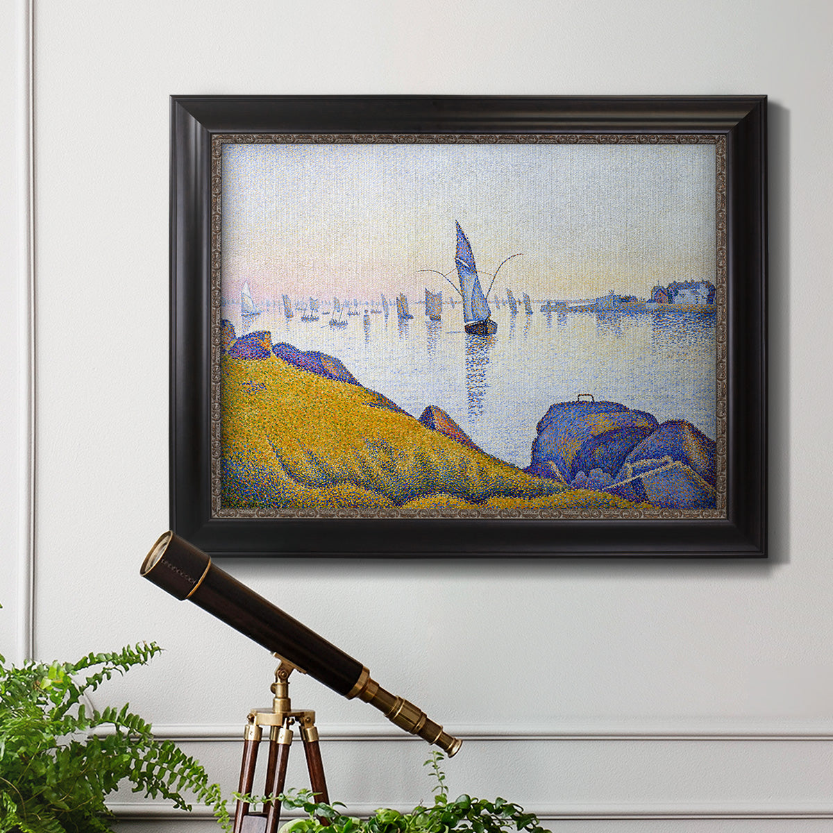 Impressionist coastal harbor at dusk by Paul Signac in an ornate black frame with gilded inner detail displayed in a light-toned interior setting.