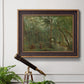 Traditional rural landscape scene with figures by Jean-Baptiste-Camille Corot in an ornate bronzed mahogany wood frame displayed in a light-toned interior setting.