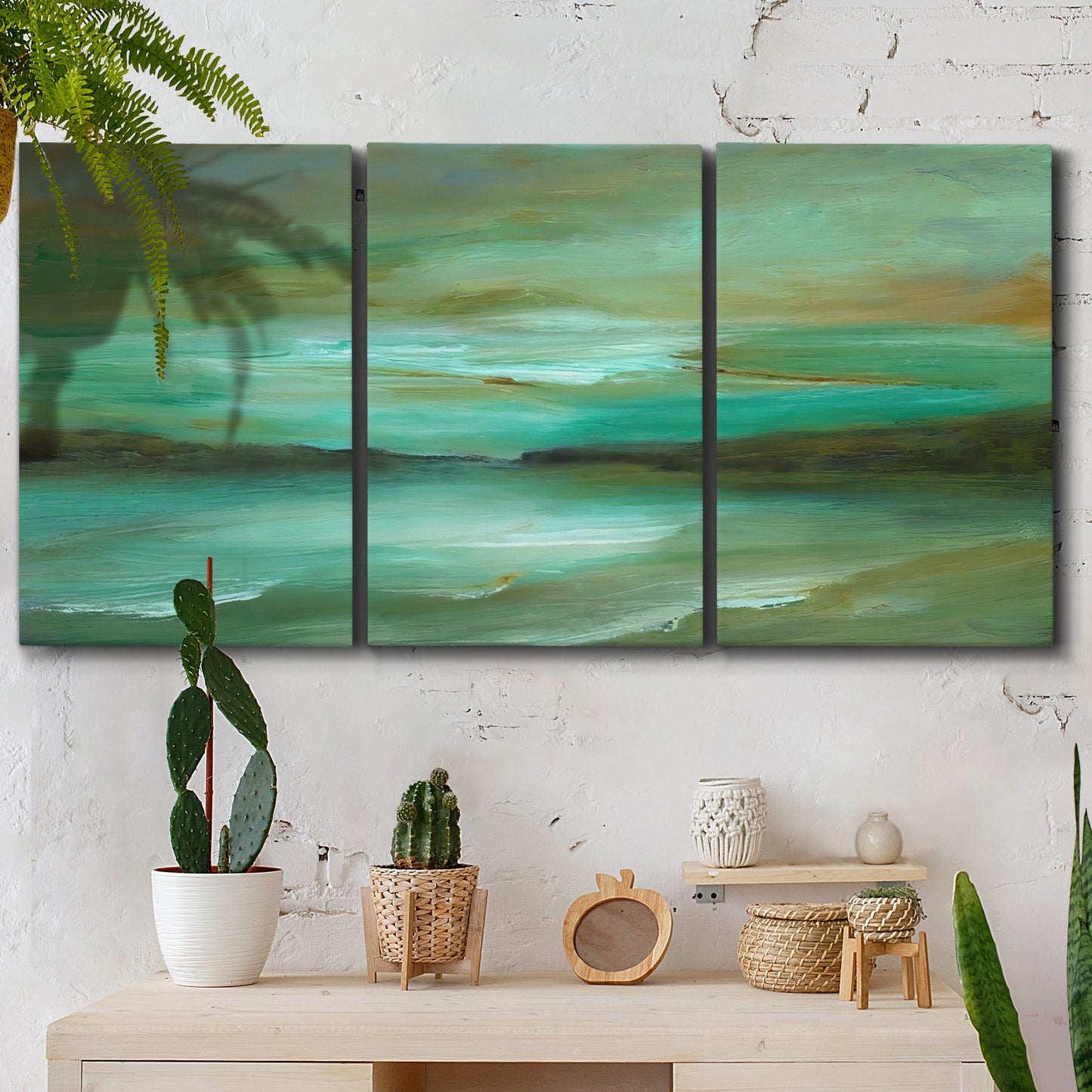Three-panel canvas wall art featuring hidden coastal cove landscape, displayed in a boho-chic entryway above a console table.
