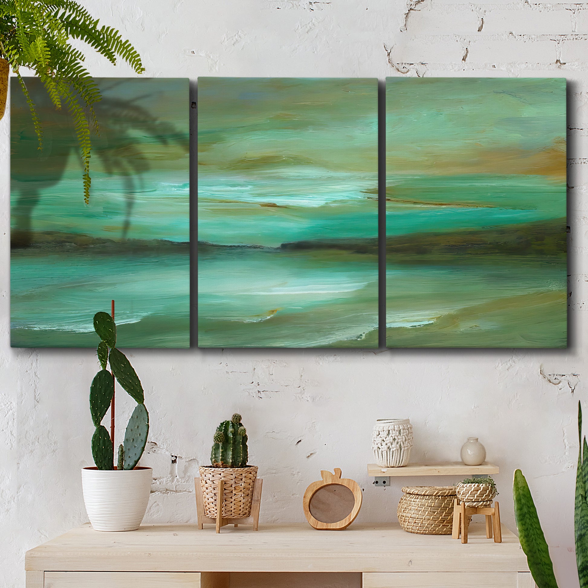 Three-panel canvas wall art featuring hidden coastal cove landscape, displayed in a boho-chic entryway above a console table.