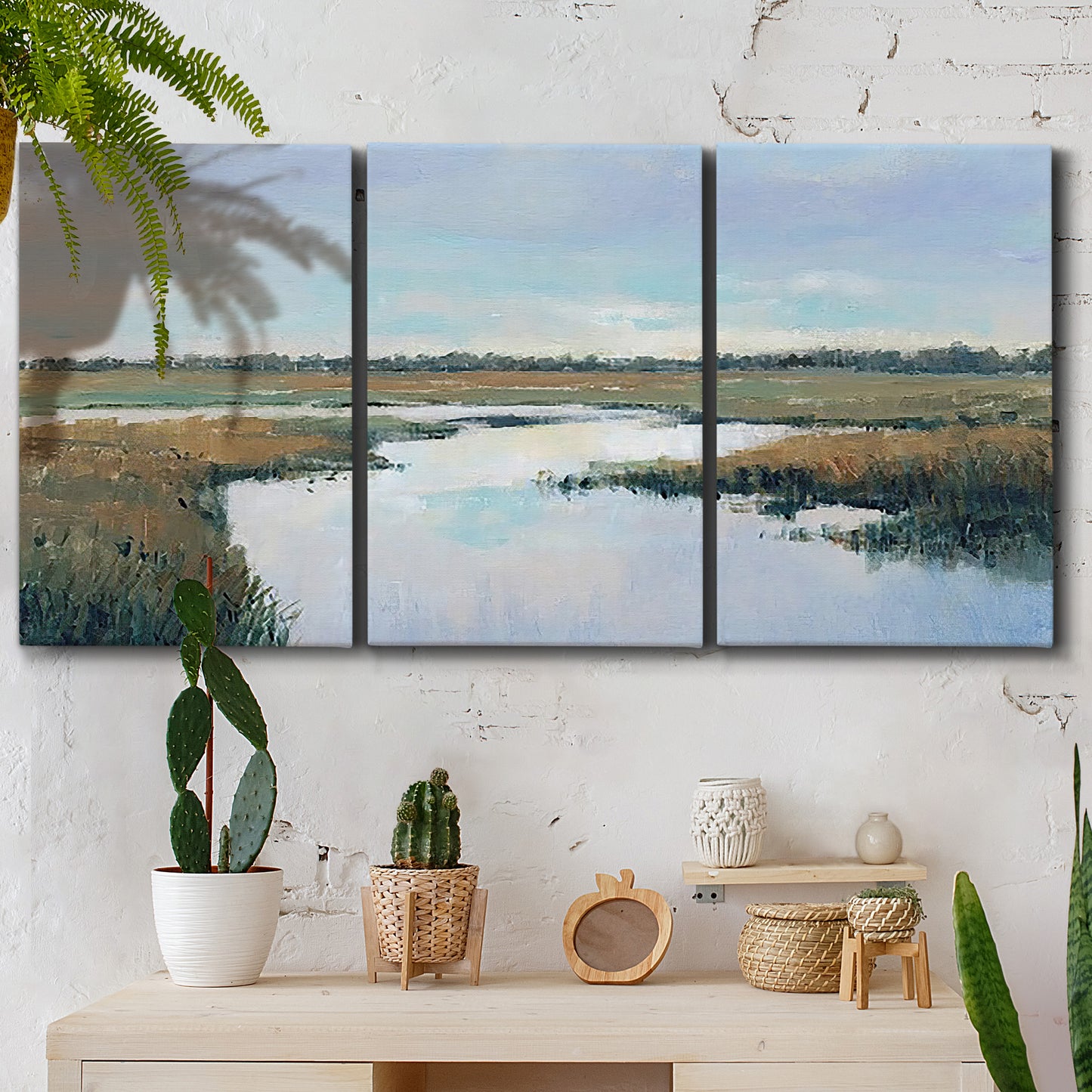 Three-panel canvas wall art featuring coastal plain meeting open water, displayed in a boho-chic entryway above a console table.