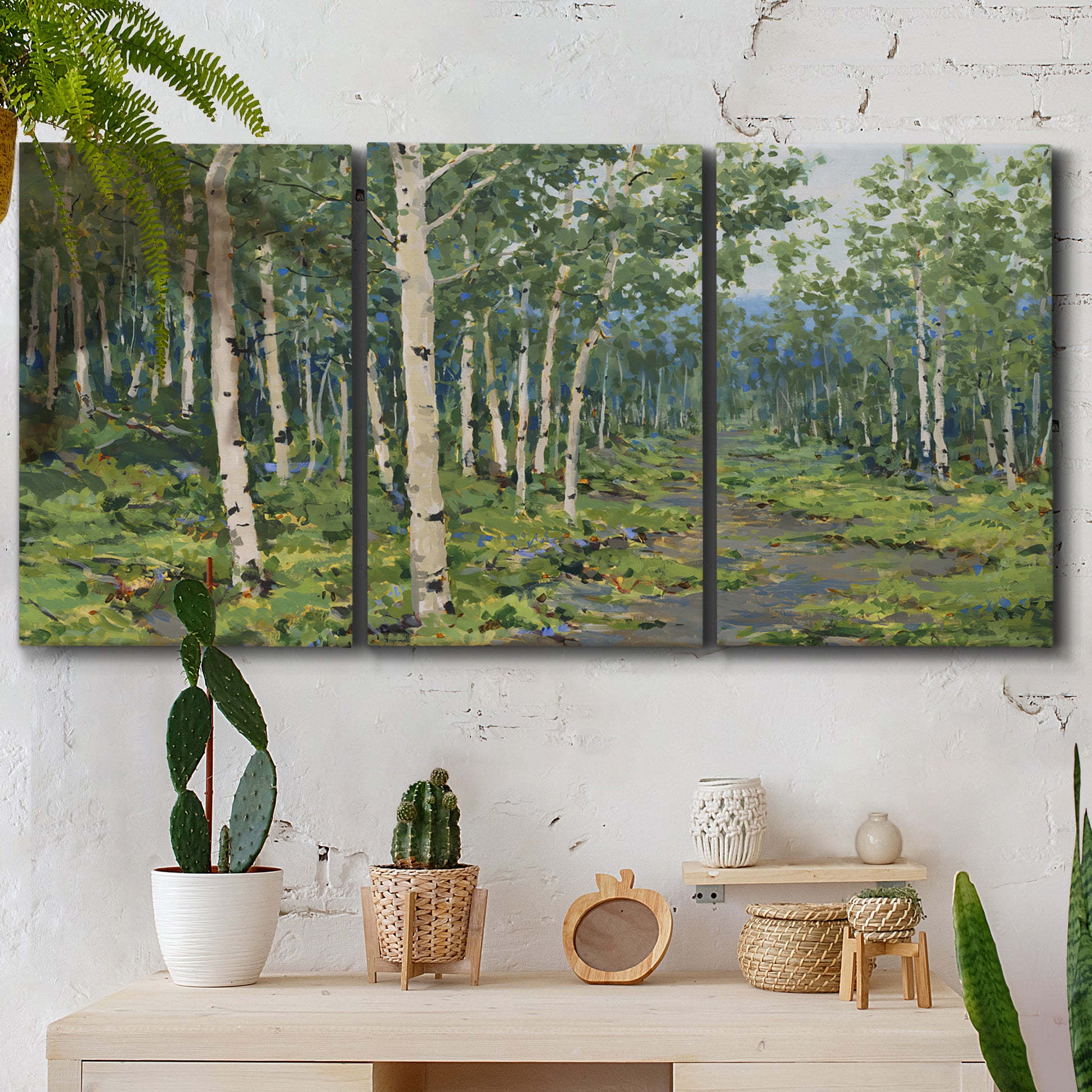 Three-panel canvas wall art featuring woodland forest scene with tall trees, displayed in a boho-chic entryway above a console table.