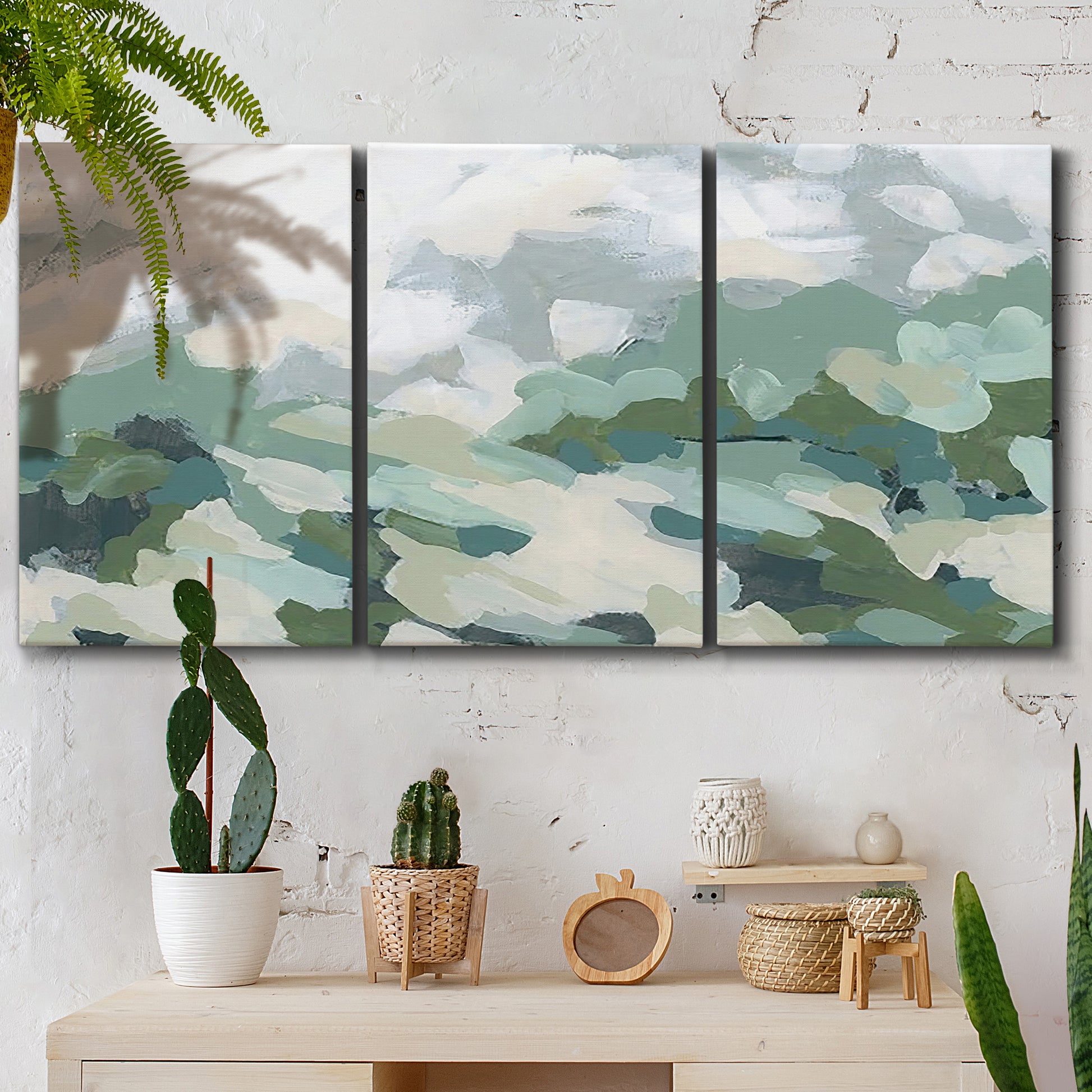 Three-panel canvas wall art featuring lush green hillside rolling landscape, displayed in a boho-chic entryway above a console table.