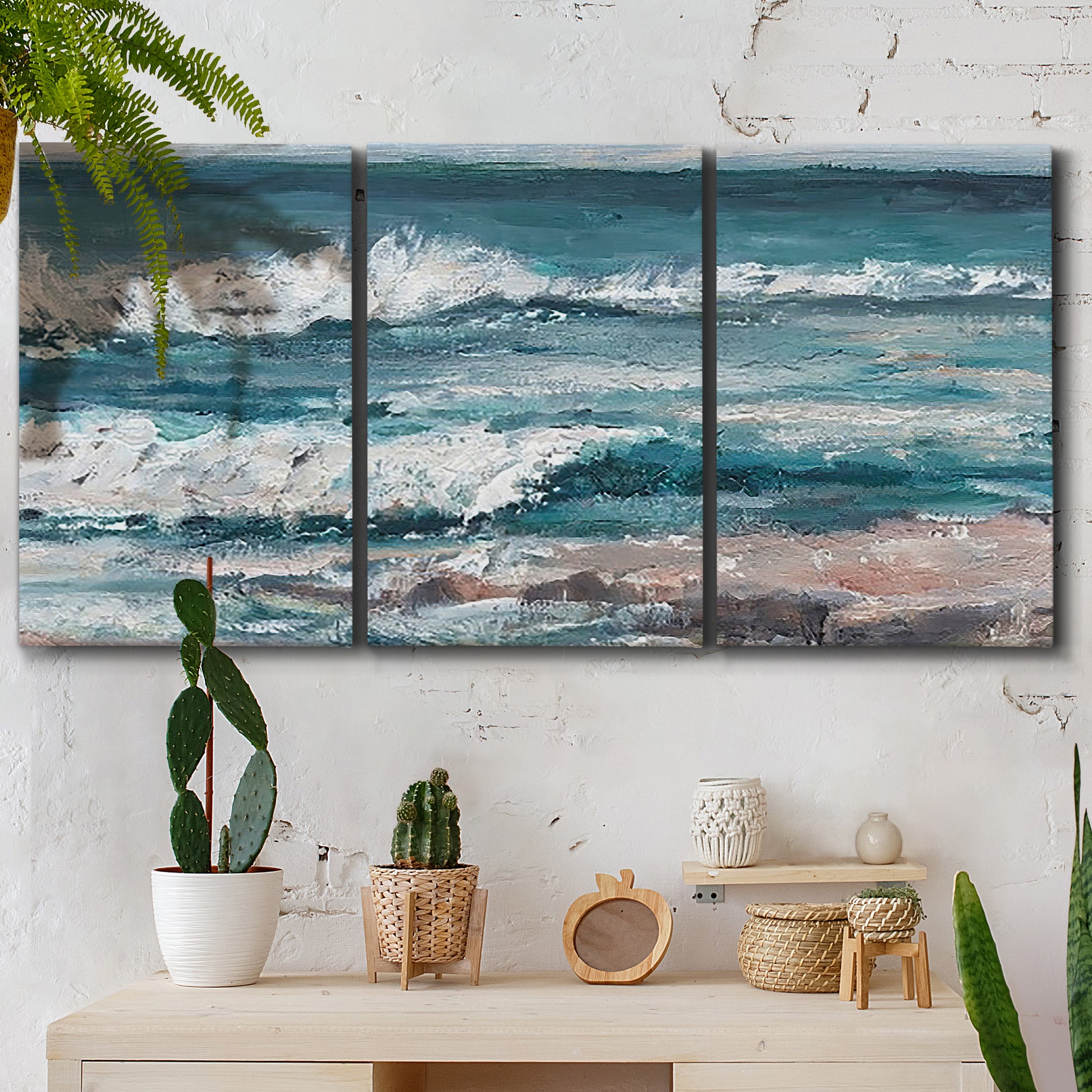 Three-panel canvas wall art featuring crashing ocean waves along shoreline, displayed in a boho-chic entryway above a console table.