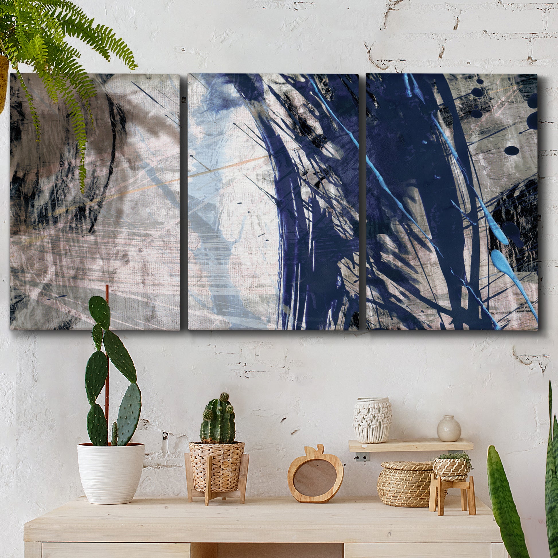 Three-panel canvas wall art featuring layered blue abstract texture, displayed in a boho-chic entryway above a console table.