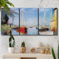 Three-panel canvas wall art featuring sailboats gathered along river, displayed in a boho-chic entryway above a console table.