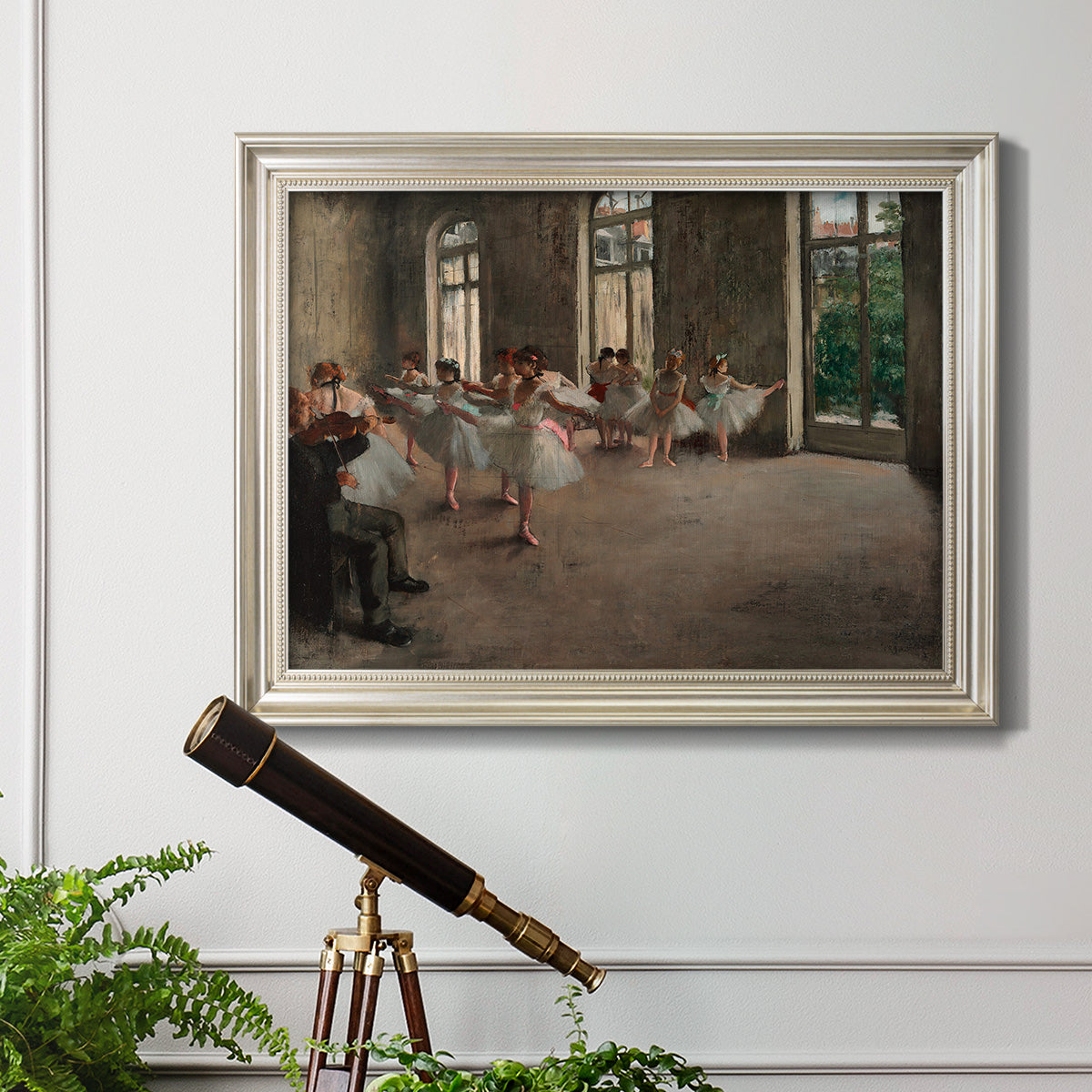 Early impressionist ballet rehearsal painting by Edgar Degas in an ornate champagne frame displayed in a light-toned interior setting.