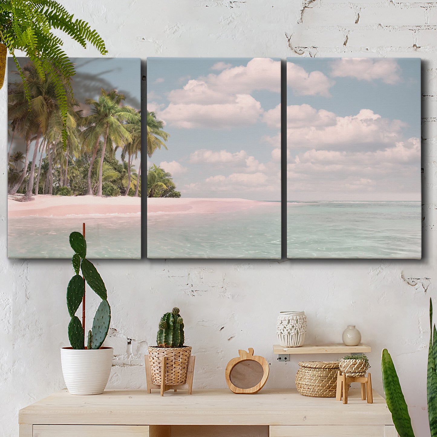 Three-panel canvas wall art featuring tropical sand dunes with palms, displayed in a boho-chic entryway above a console table.