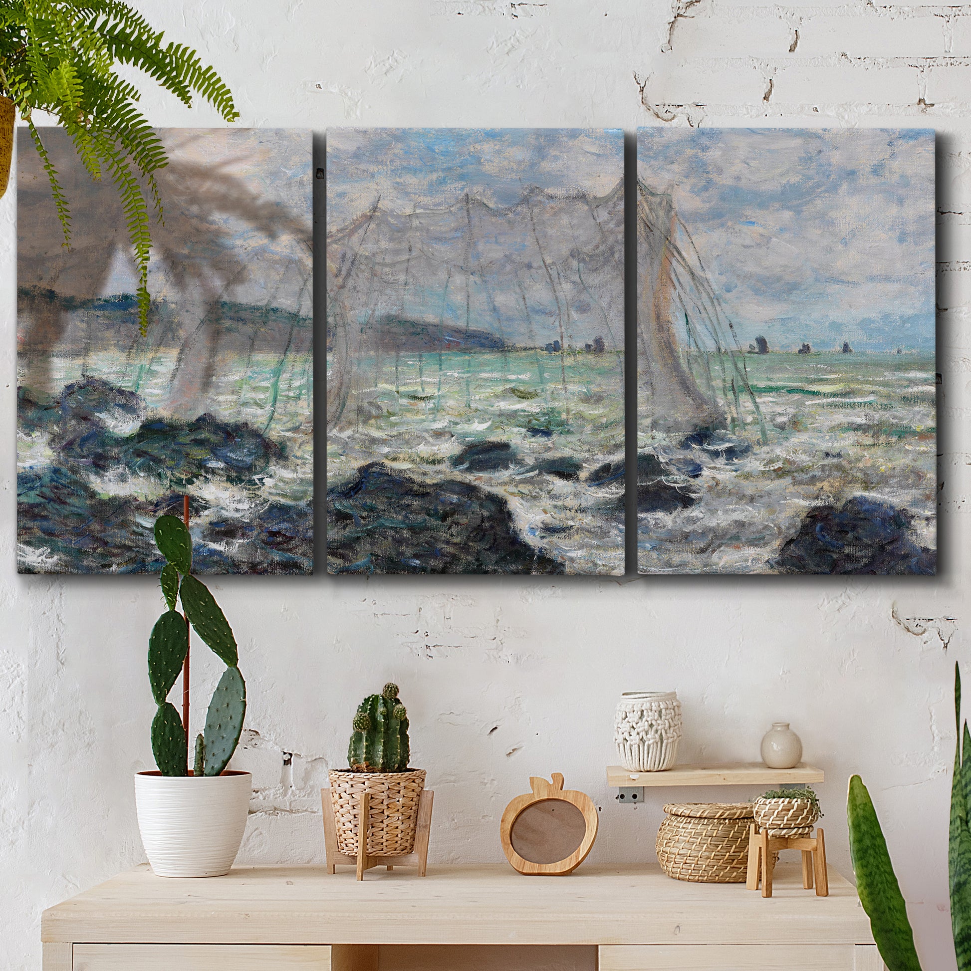 Three-panel canvas wall art featuring rough seas along rocky coast, displayed in a boho-chic entryway above a console table.
