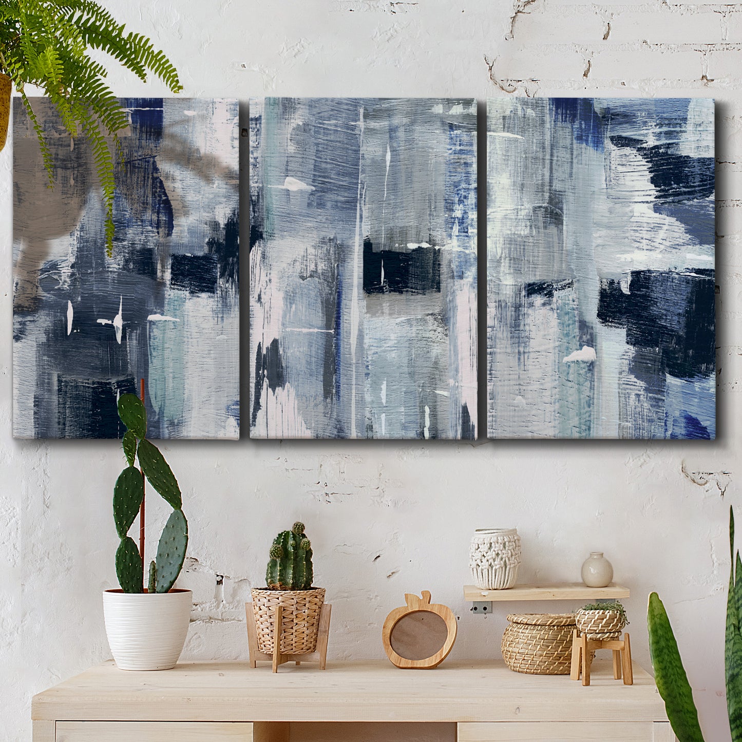 Three-panel canvas wall art featuring soft abstract mountain color fields, displayed in a boho-chic entryway above a console table.