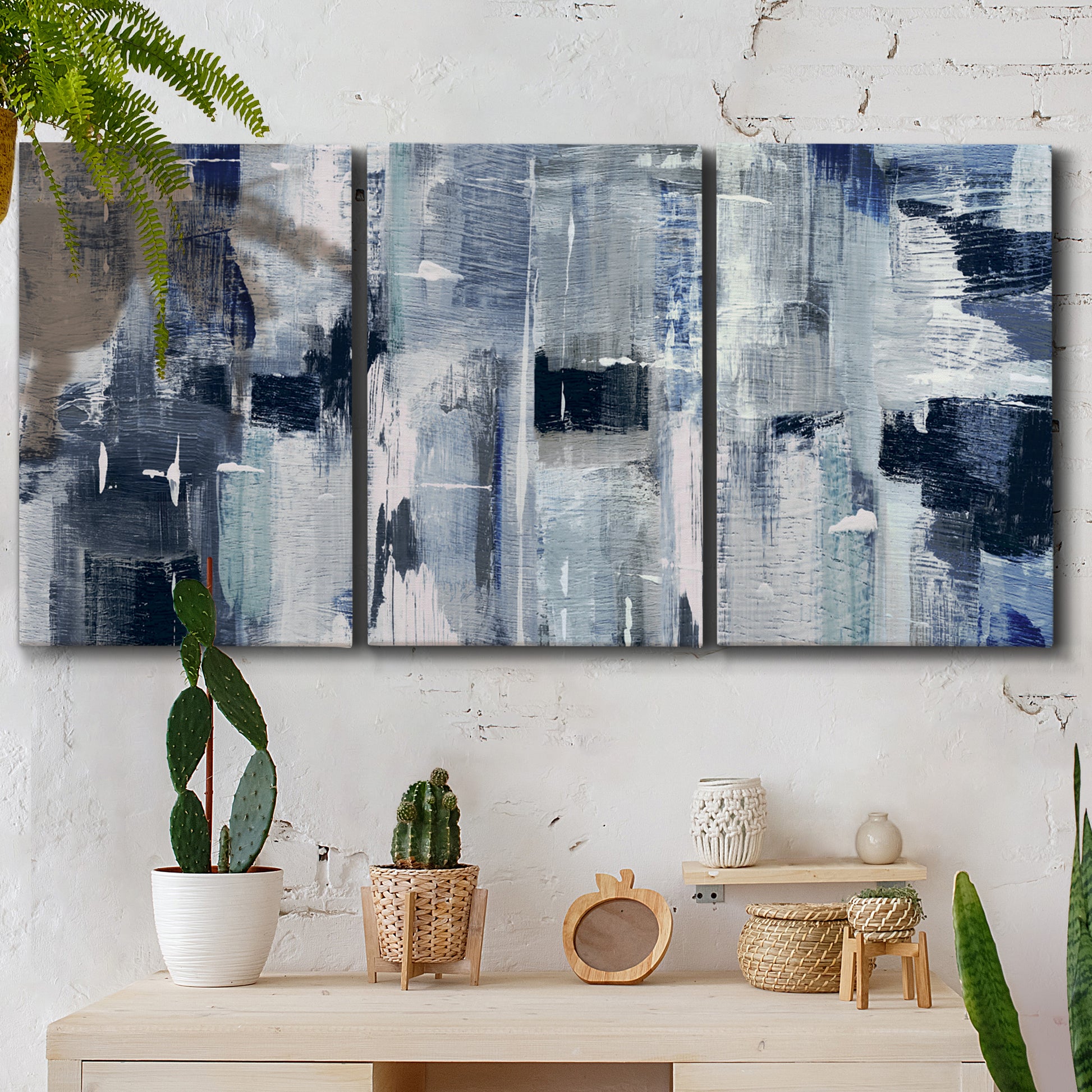Three-panel canvas wall art featuring soft abstract mountain color fields, displayed in a boho-chic entryway above a console table.