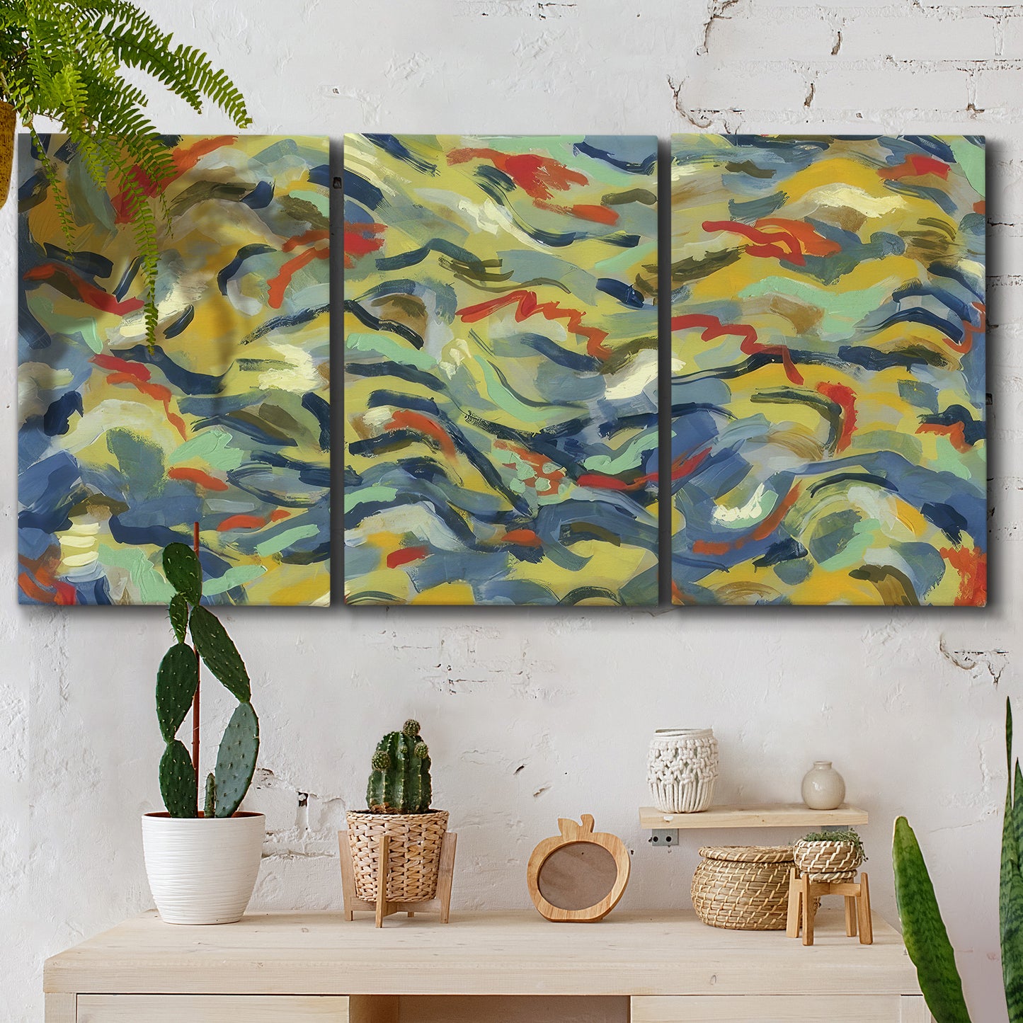 Three-panel canvas wall art featuring colorful abstract river like motion, displayed in a boho-chic entryway above a console table.
