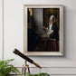 Quiet interior genre scene of a woman with scales by Johannes Vermeer in an ornate champagne frame displayed in a light-toned interior setting.