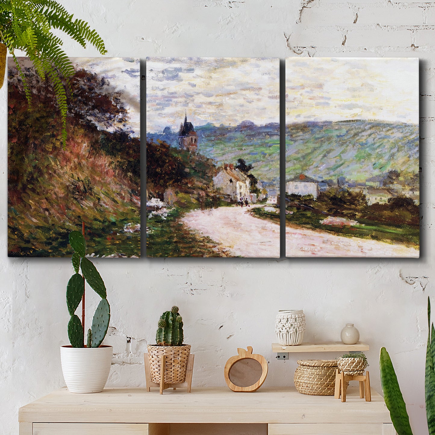 Three-panel canvas wall art featuring country road through village, displayed in a boho-chic entryway above a console table.