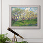 Impressionist spring orchard landscape by Vincent van Gogh in an ornate weathered white frame displayed in a light-toned interior setting.