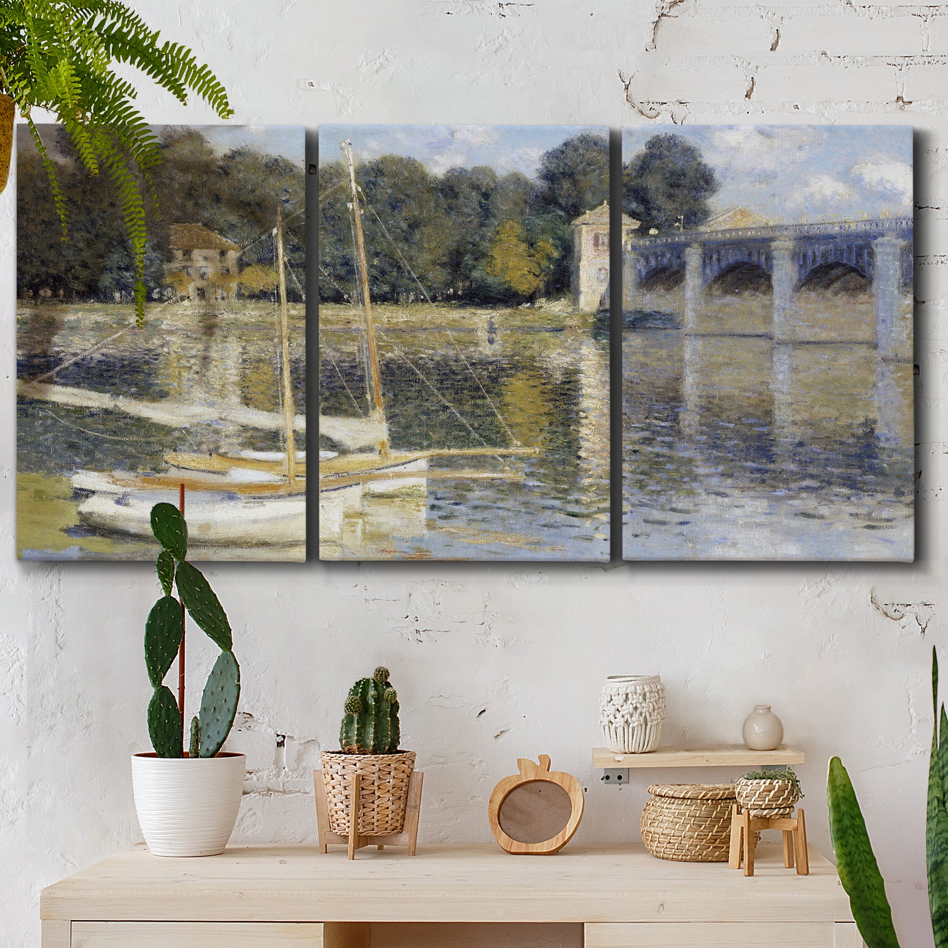 Three-panel canvas wall art featuring bridge crossing broad river, displayed in a boho-chic entryway above a console table.