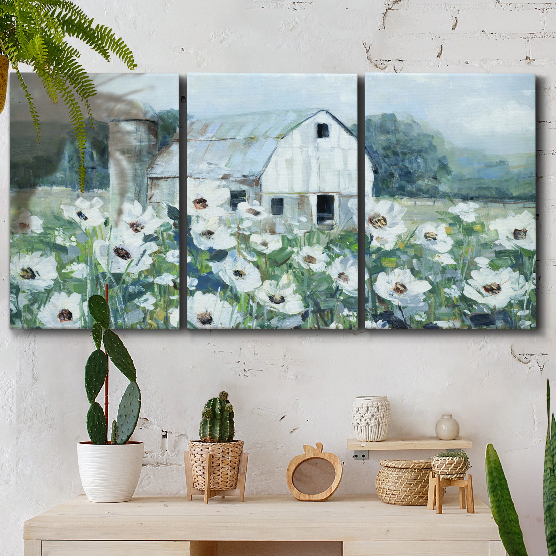 Three-panel canvas wall art featuring pastoral farmland with open fields, displayed in a boho-chic entryway above a console table.