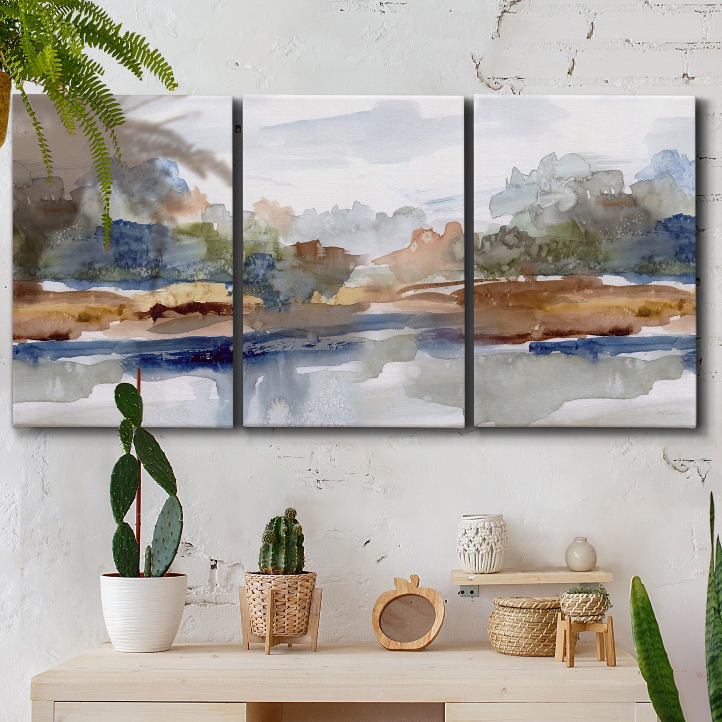 Three-panel canvas wall art featuring layered abstract mountain forms, displayed in a boho-chic entryway above a console table.