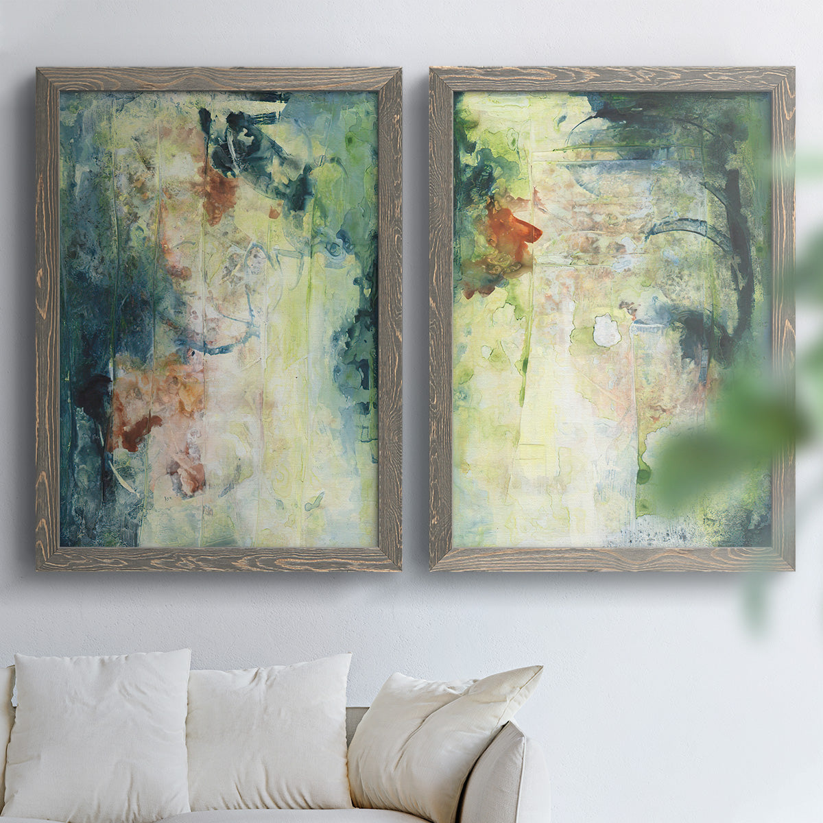 Set of two gray barnwood framed canvas prints depicting vertical organic marks, pale light passages, and weathered surfaces arranged across two complementary compositions above a sofa in a bright living space.