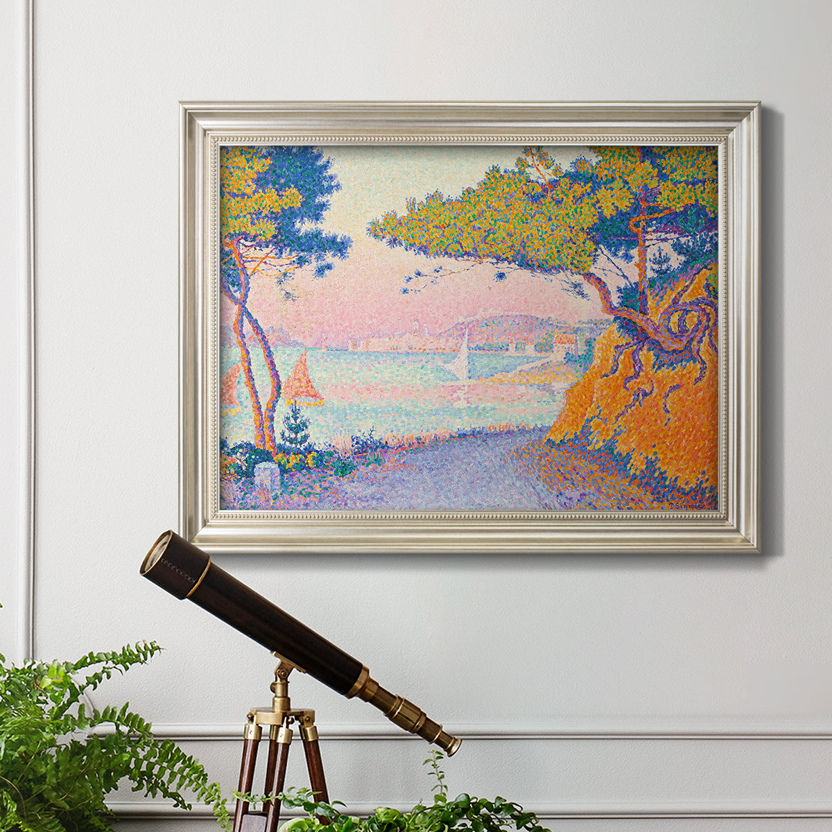 Pointillist coastal seascape by Paul Signac in an ornate champagne frame displayed in a light-toned interior setting.
