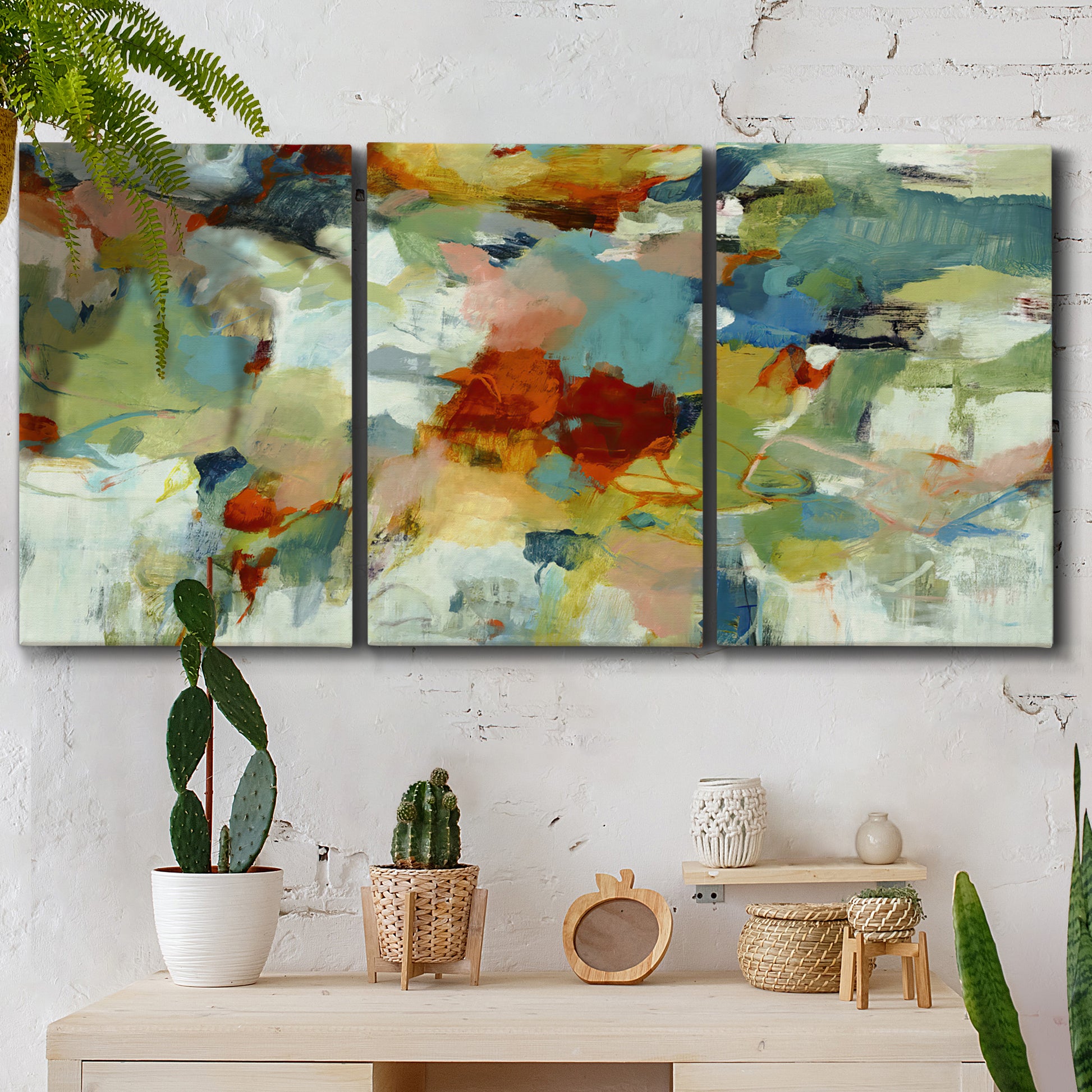 Three-panel canvas wall art featuring celebratory abstract color movement, displayed in a boho-chic entryway above a console table.