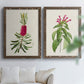 Set of two walnut barnwood framed canvas prints depicting peonies thistles leafy stems and archival cream paper arranged across two complementary compositions above a sofa in a bright living space.