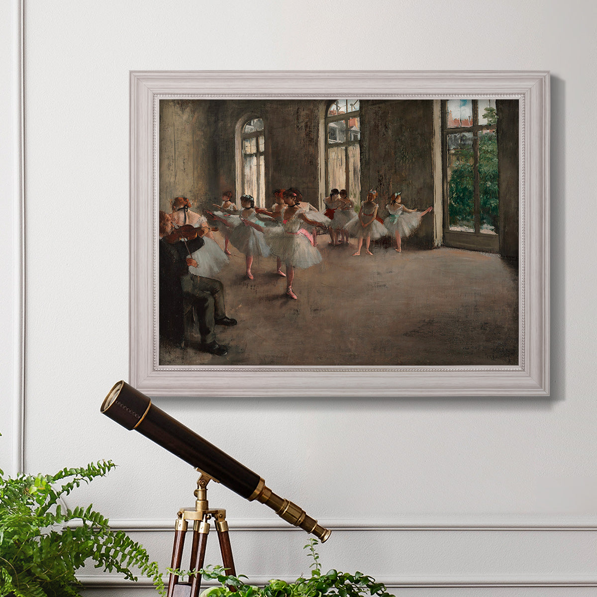 Early impressionist ballet rehearsal painting by Edgar Degas in an ornate weathered white frame displayed in a light-toned interior setting.